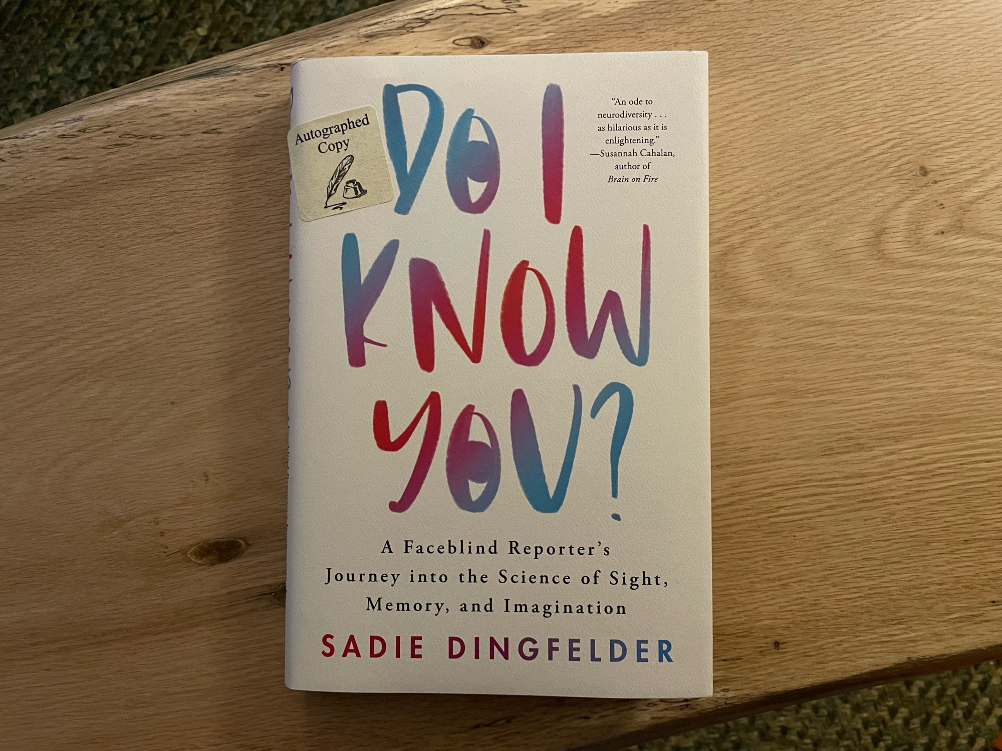 Photo of a book on a wood bench. Text on cover: “Do I Know You? A Faceblind Reporter’s Journey into the Science of Sight, Memory, and Imagination // Sadie Dingfelder”