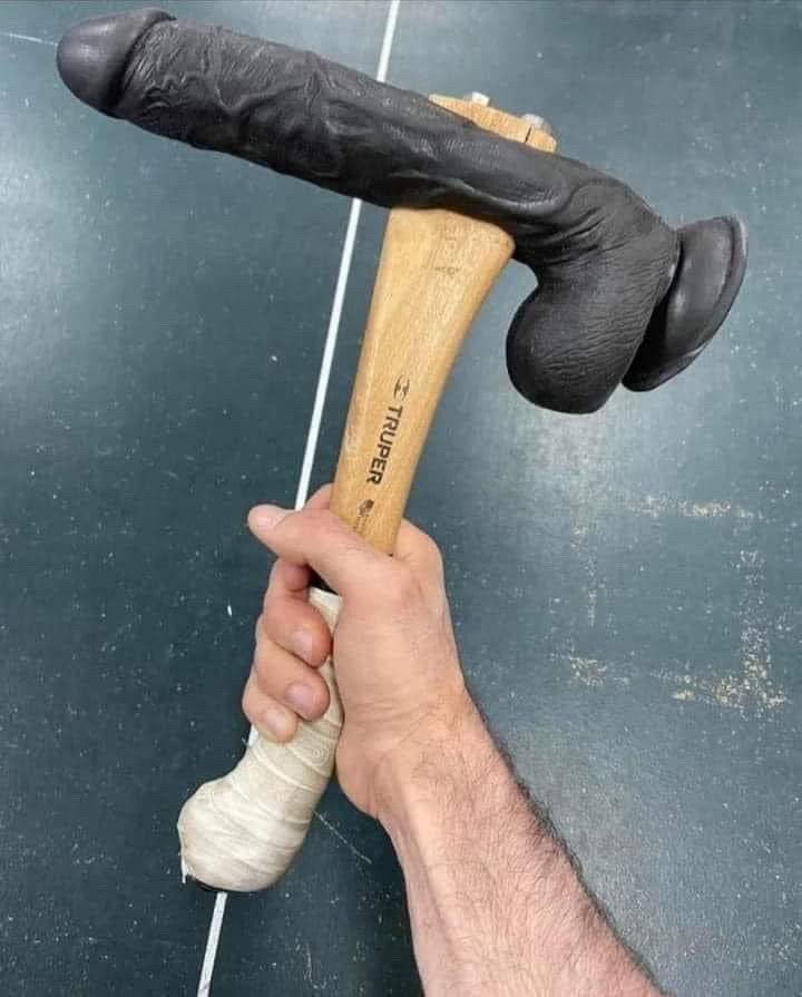 Hand holding a dildo hammer 