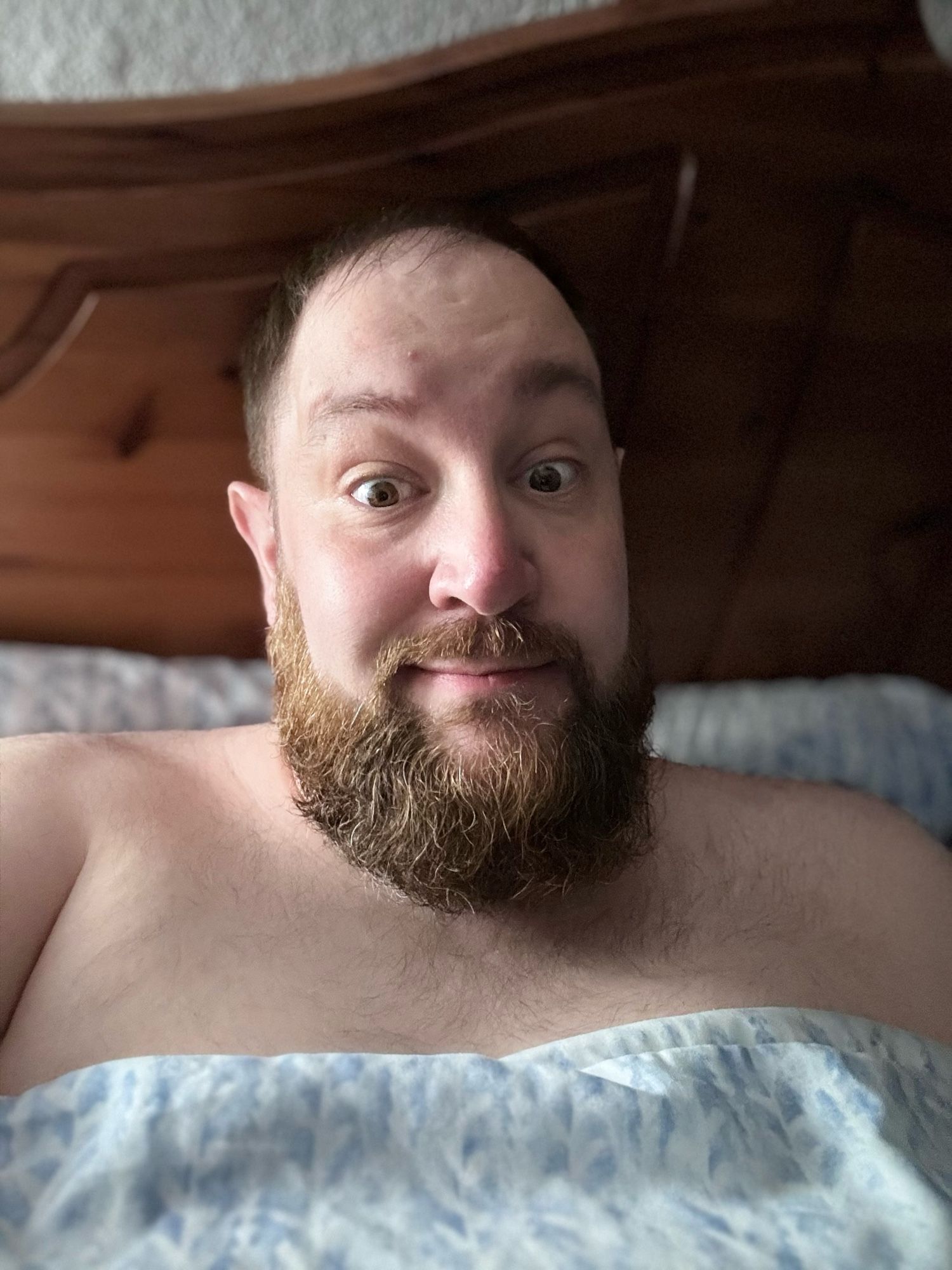 Me in bed pulling a silly face