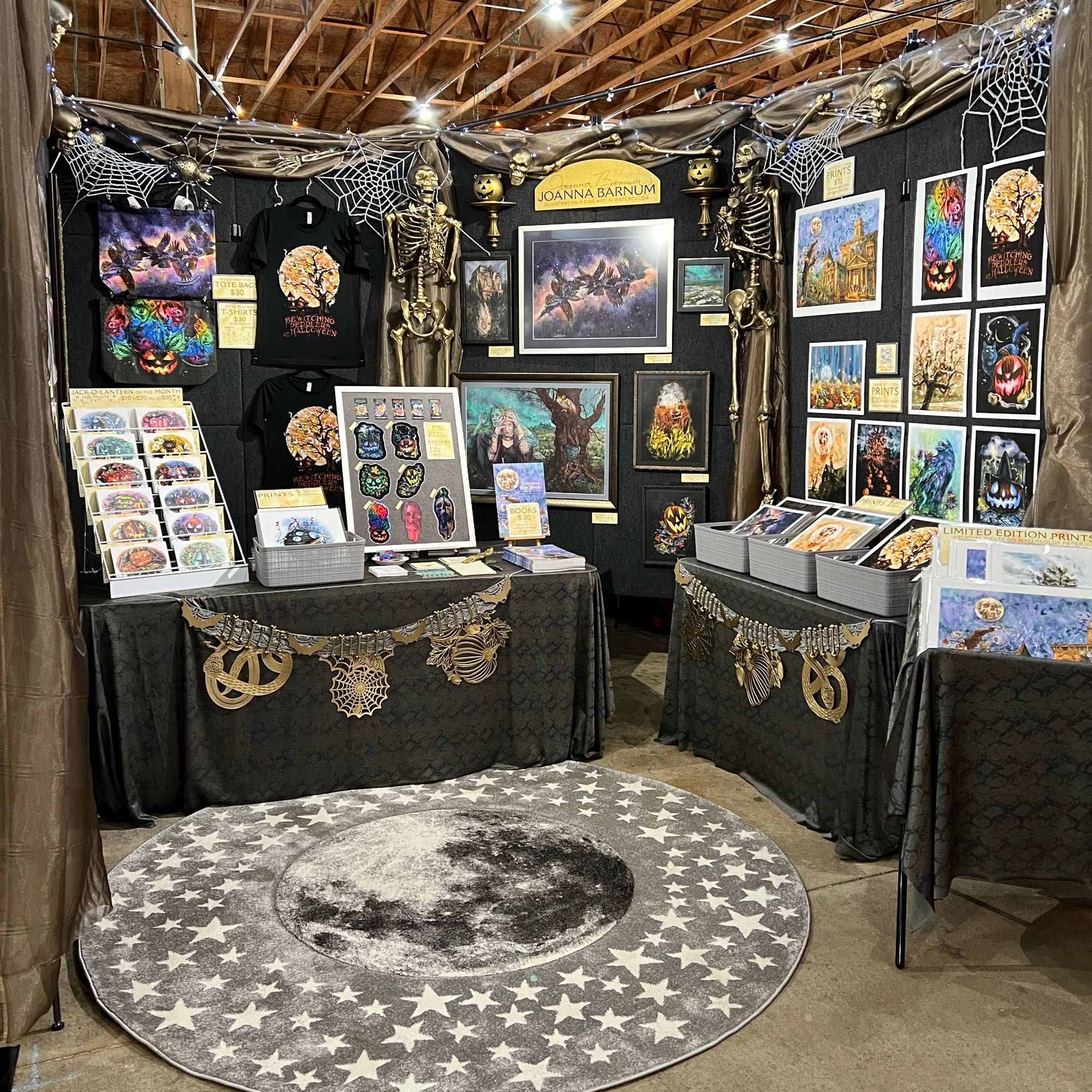 Photo of an artist booth decorated with gold and silver Halloween bones and spiderwebs.