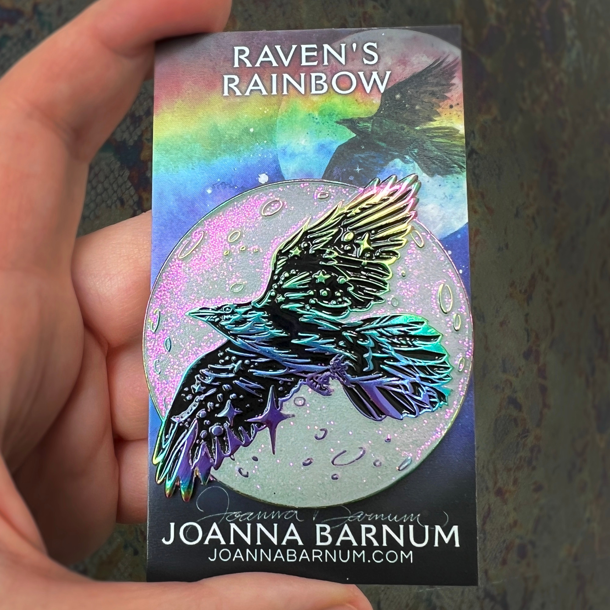 Enamel pin of a holographic raven with a glittery moon