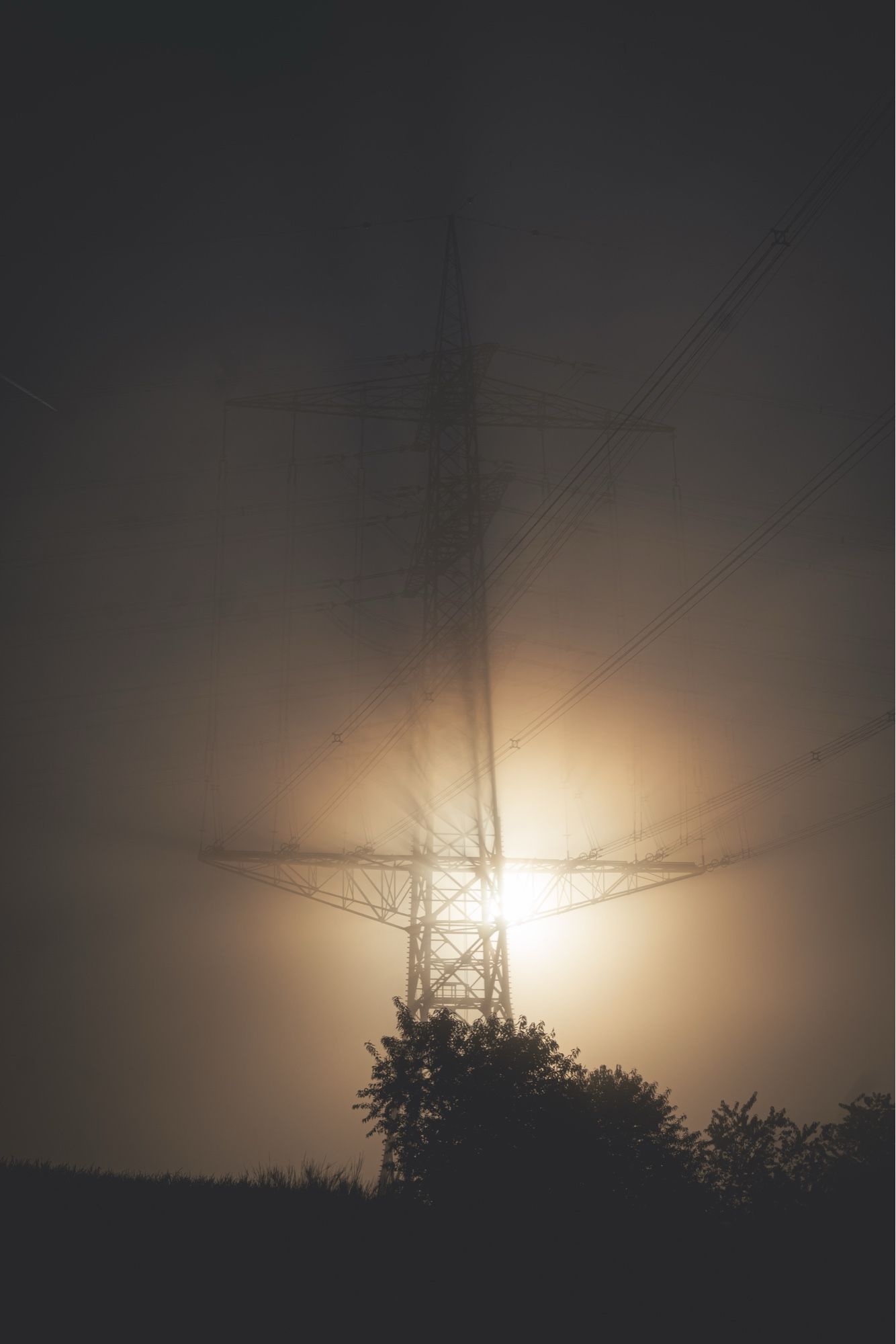 Neblige Landschaft mit Strommast, Sonnenlicht gefiltert durch den Nebel