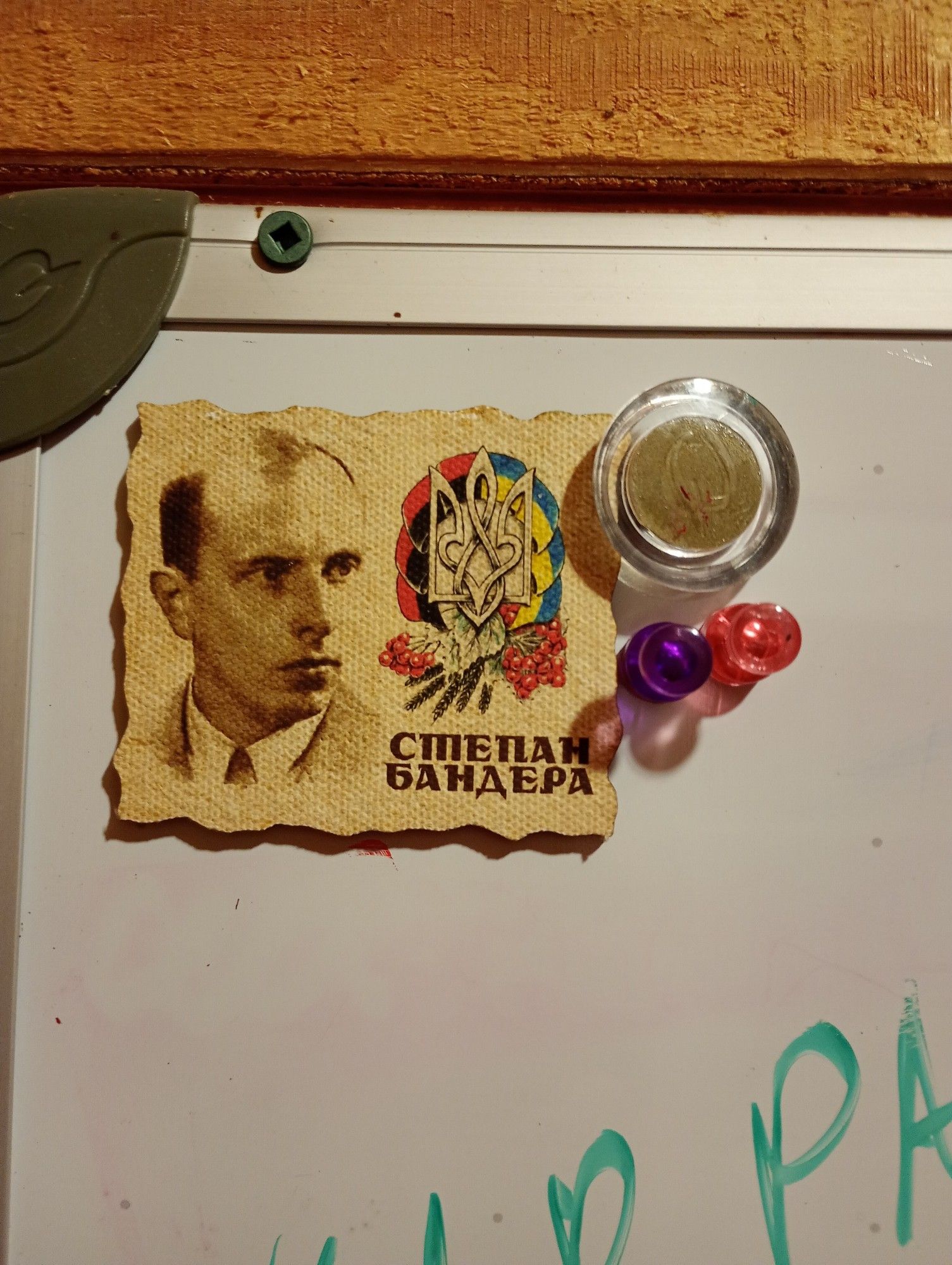 A small image of fascist Ukrainian Stepan Bandera, may he rest in piss, is stuck to a white board in the nurses station of a children's camp