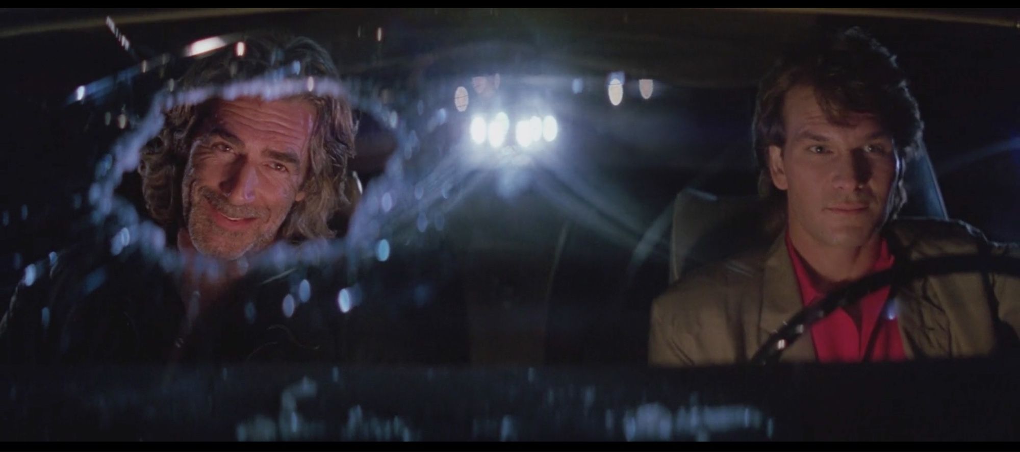 Scene highlighting the work of cinematographer Dean Cundey in the movie Road House (1999). Patrick Swayze is driving on the right side of the image, on the left is Sam Elliot. Elliot’s face is perfectly framed within a hole punched into the windshield.