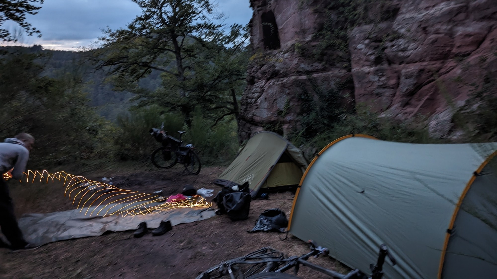 Two tents pitched aside of castle ruins, in the middle of the forest.