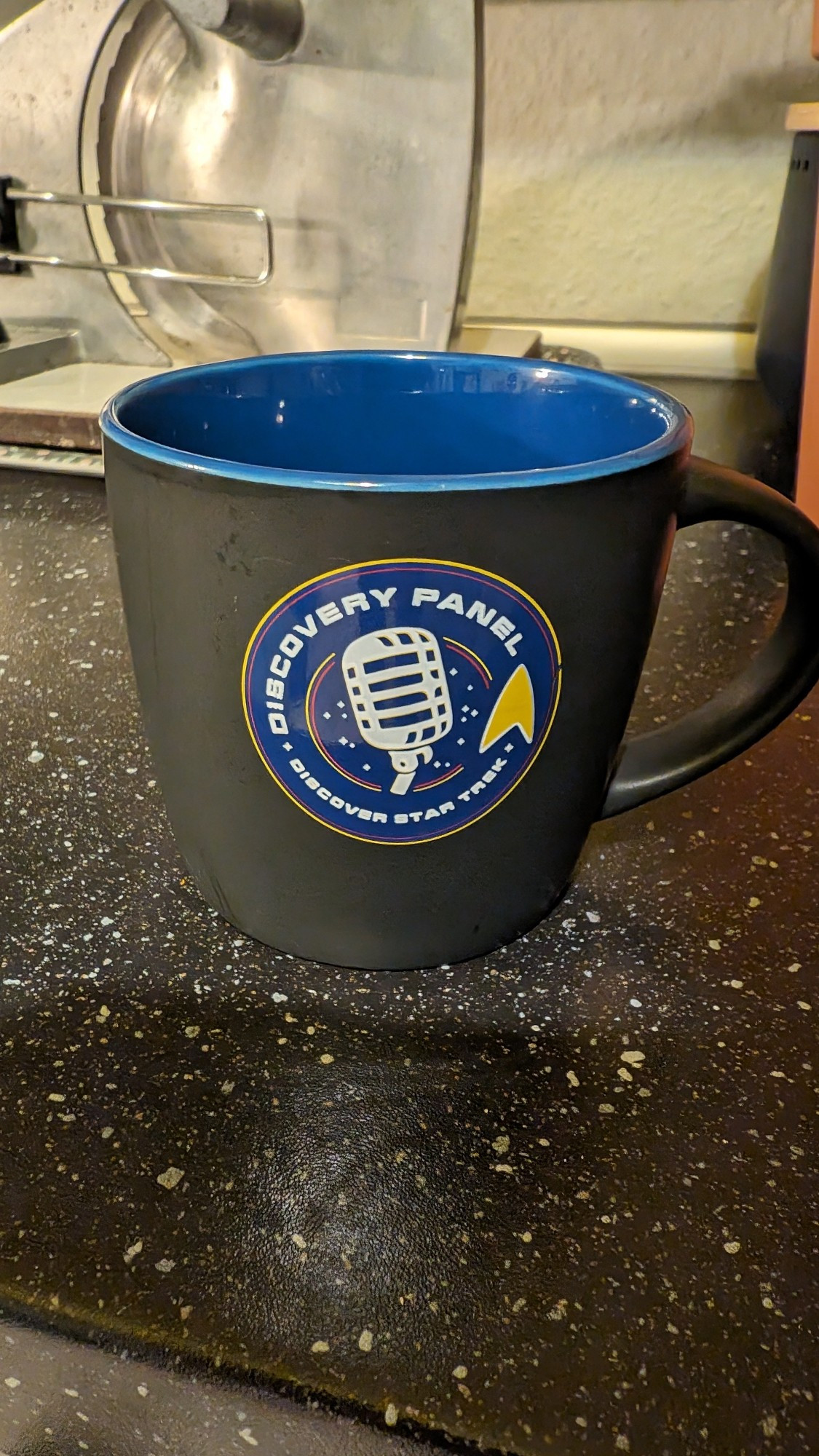 Schwarze Tasse mit Logo des "Discoverypanel-Podcast"