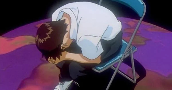 The Evangelion character, Shinji, sitting in a chair with his head in his hands