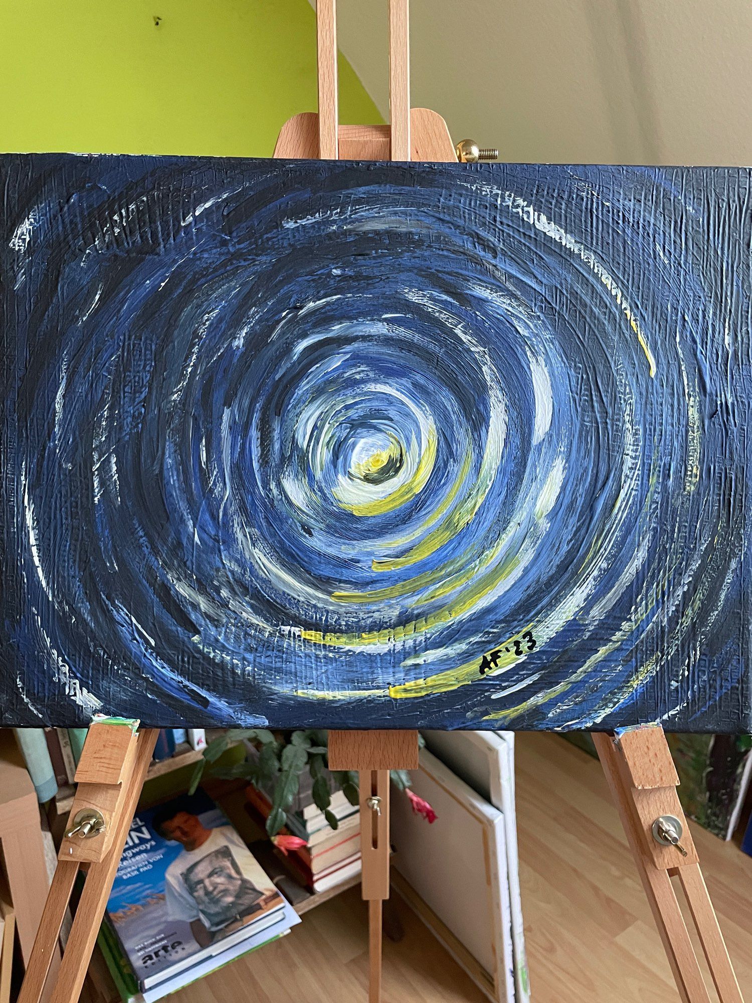 Kreise in blau, grau/schwarz und weiß sowie teils gelbe Lichteffekte vor schwarzem Hintergrund. Acryl auf Keilrahmen 40 x 30 cm, steht zum Verkauf von mir als Freiberuflerin im Rahmen der Aktion: #ArtForEmma, freue mich einfach über deine Email mit deiner Preisvorstellung an: antje25001 (at) gmx.de
Auf dem Foto sind außer dem Bild: die Staffelei, darunter Bücher (eins über Hemingway, von Michael Palin geschrieben), Leinwände auf dem Boden stehend sowie eine hellgrüne und weiße Tapete im Hintergrund.