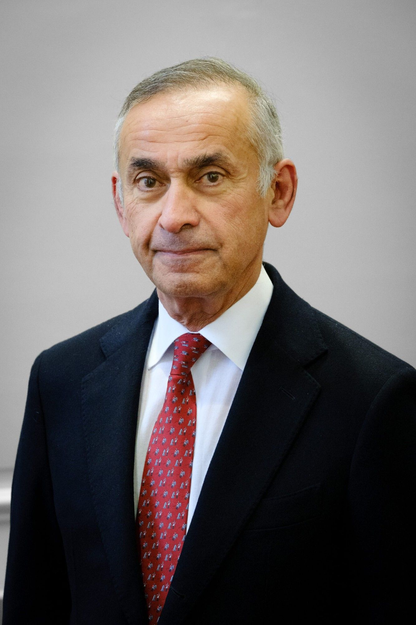 A photo of Lord Darzi, wearing a suit and a red tie.