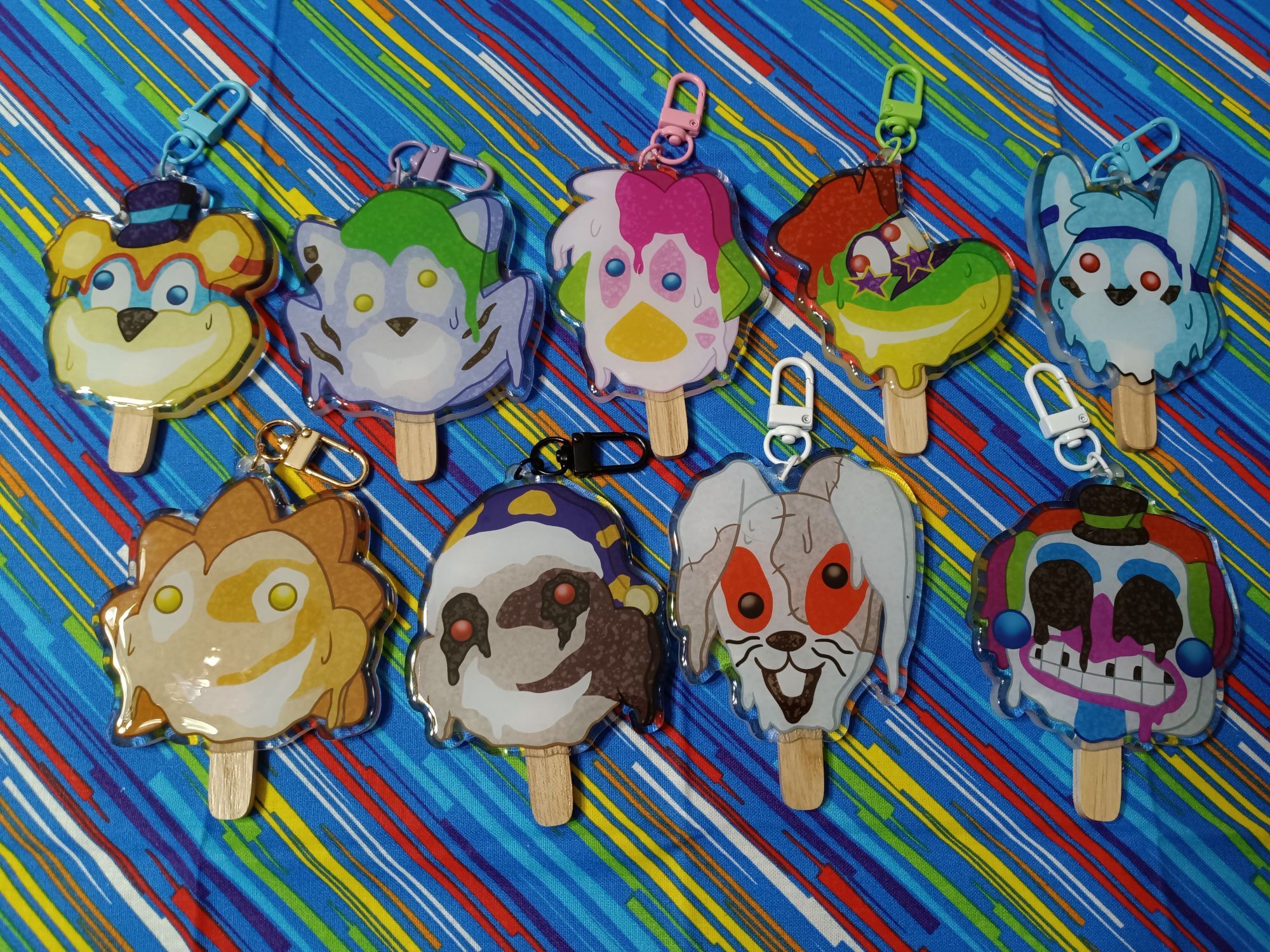 A group of acrylic charms made to look like melting popsicles. They depict characters from the game Five Nights at Freddy's Security Breach.