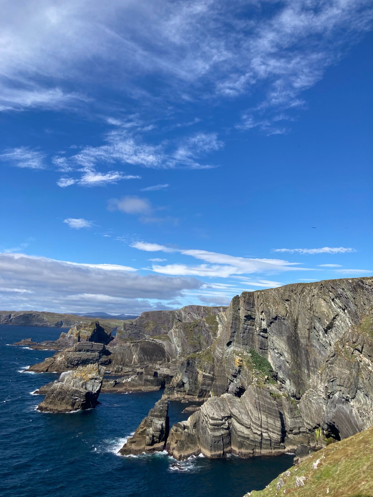 View of the cliffs and Atlantic Ocean at Mizen Head, Ireland, under a blue sky