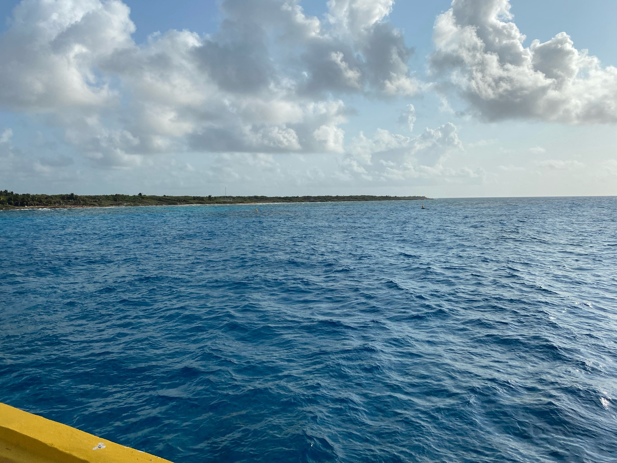 For everyone freaking out about the upcoming USA political season, take a break and enjoy a crappy picture of a beautiful sea. Clouds and blue waters, with the edge of a yellow pier and trees across the horizon.