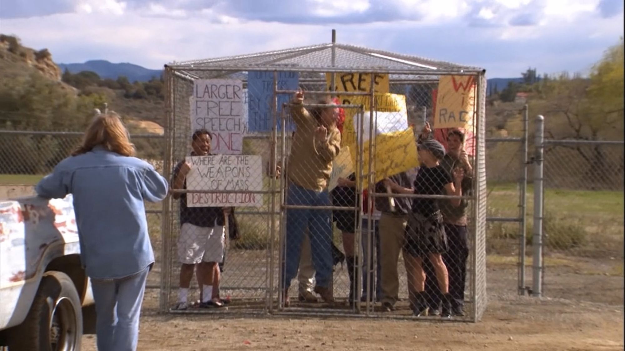 Protesters in a cage, a reference to Bush era protests.