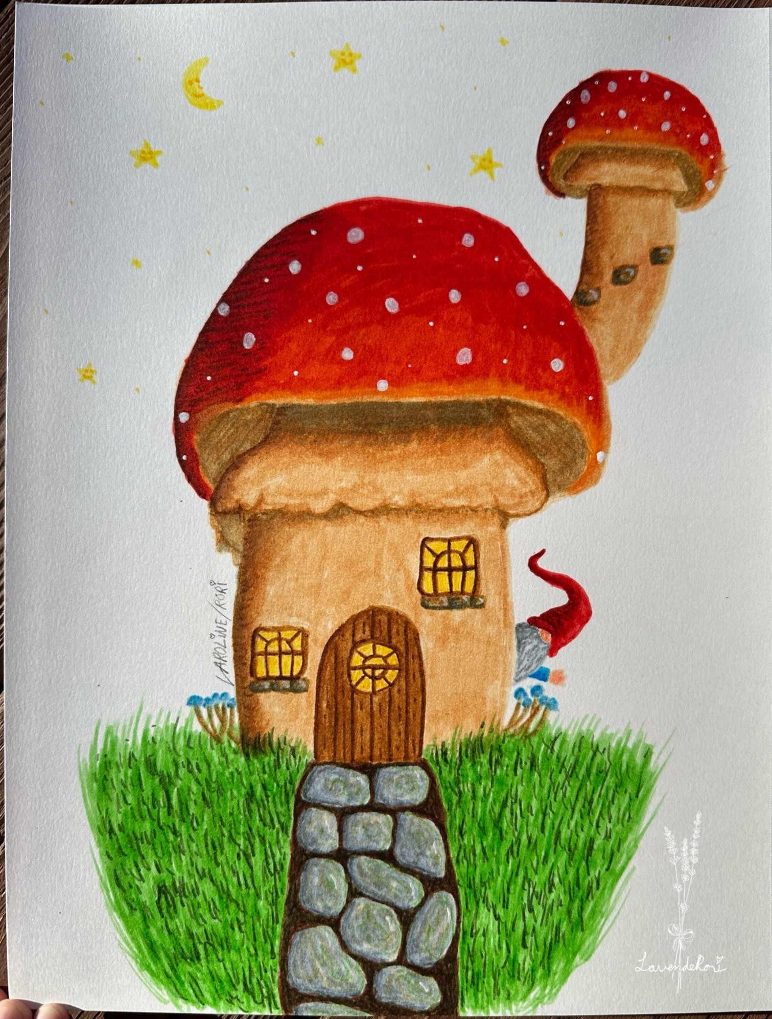 a mushroom house with a red cap with white dots. there are two windows on either side of the front door, the one of the right is higher than the door goes. there is a stone brick shelf below each of those windows. a stone path leads to the door, with grass on either side. the wooden door is rounded at the top and has a circle window. each window has a yellow glow like there’s light inside. another, smaller, mushroom grows off the cap of the bigger one, resembling a chimney. there are three stone bricks on the chimney like a staircase. at the base of the house, on either side, a patch of blue capped mushrooms grows. on the right side of the house, a gnome with a big red hat covering their eyes peaks out and waves hello. they have a gray beard and a blue sleeve. above the house are yellow stars and a waning crescent moon with a smiley face. in the bottom right corner is the artist, lavenderori, watermark