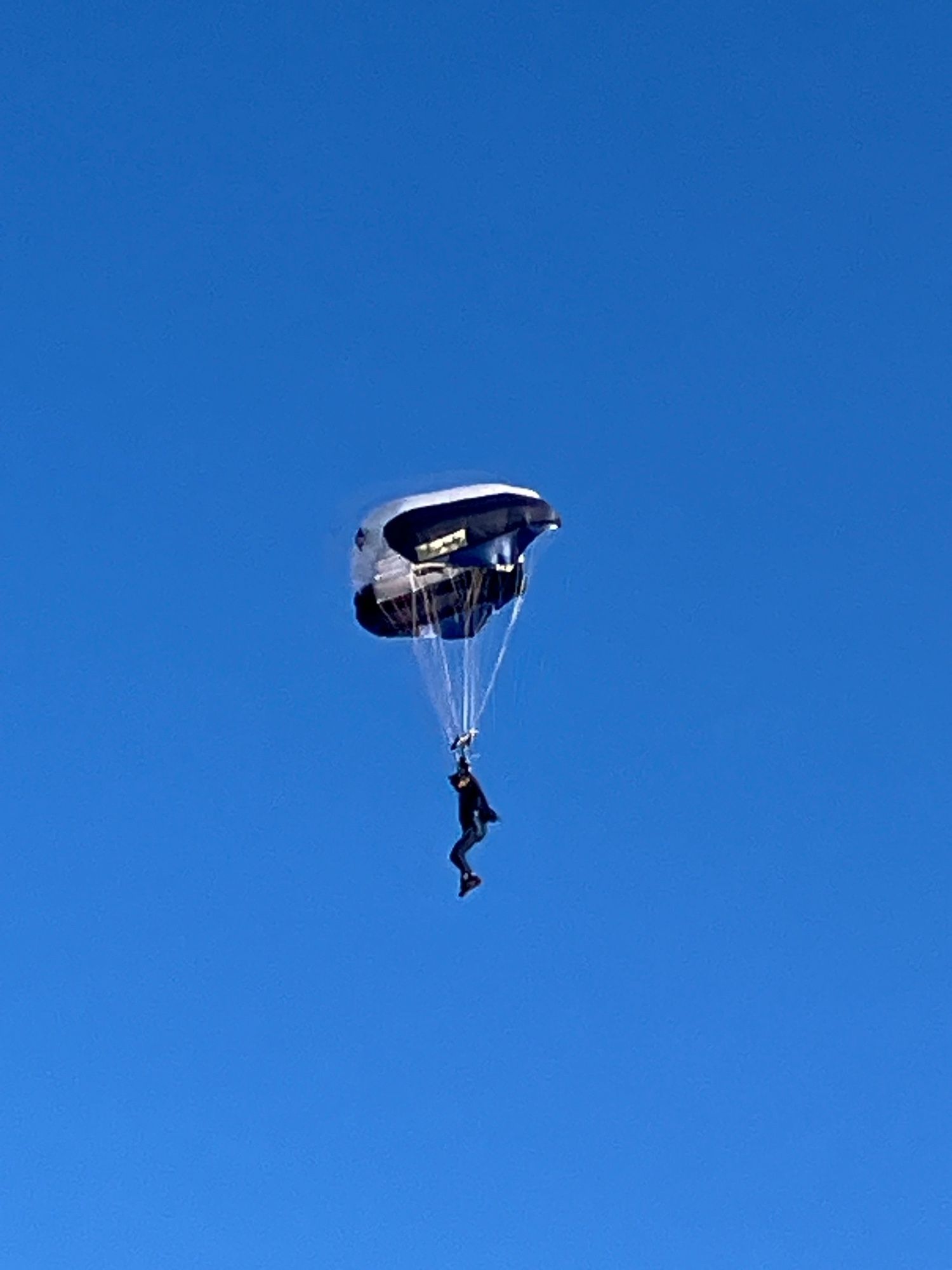 Ein Fallschirmspringer vor blauem Himmel