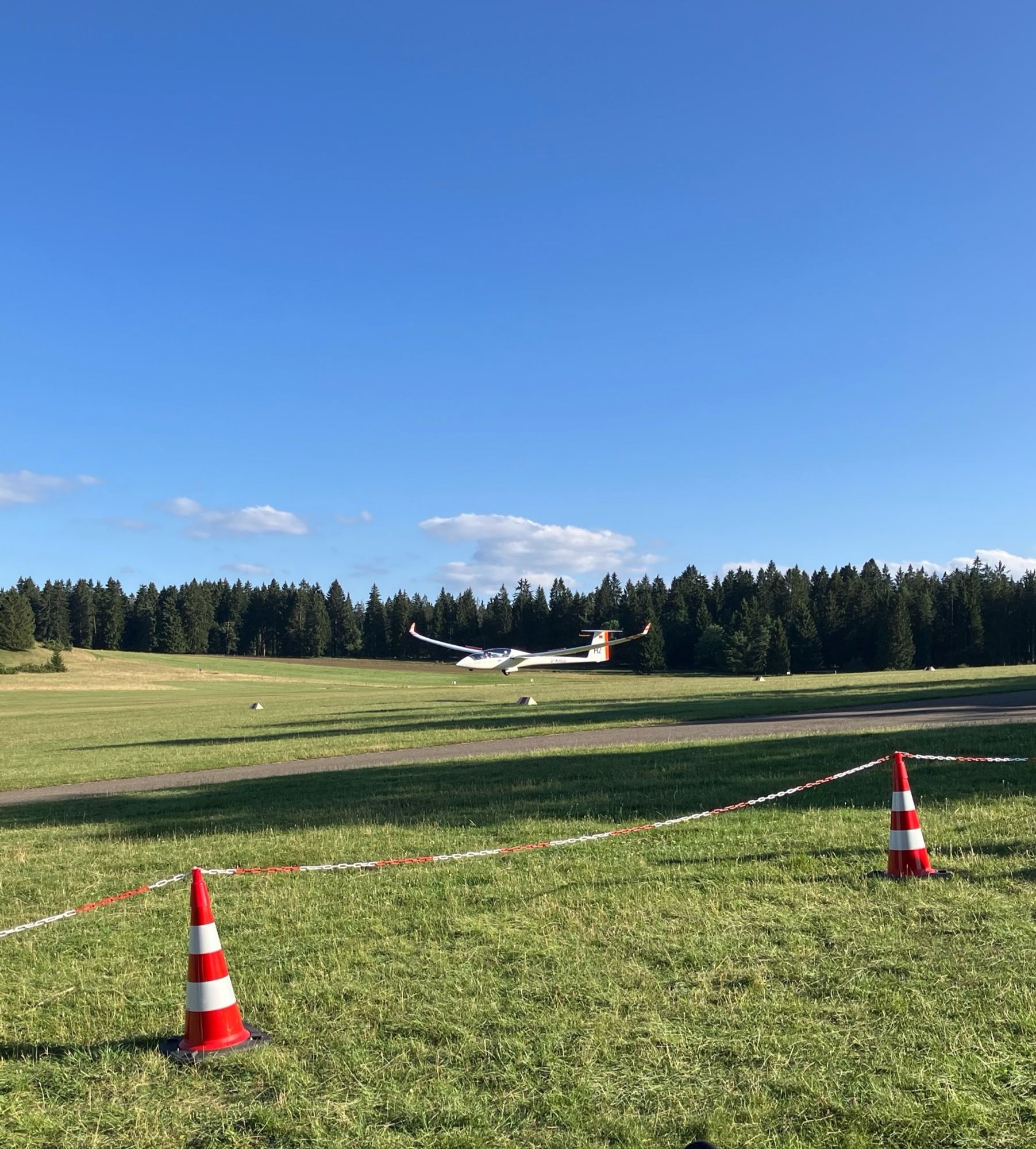 Ein landendes Segelflugzeug kurz über dem Boden