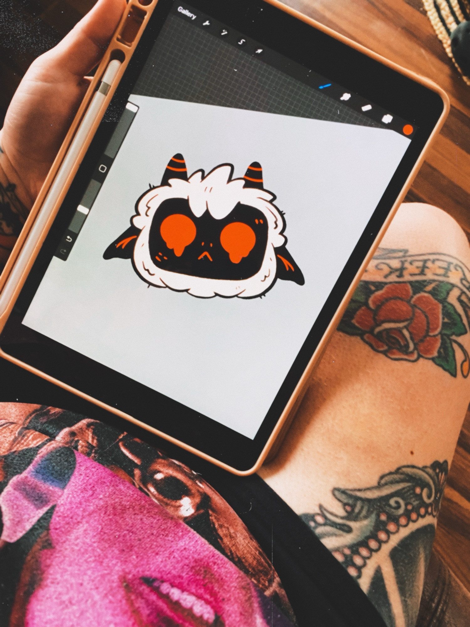 a photo of an ipad screen drawing. it’s a cartoon lamb from the video game cult of the lamb. his eyes are red and melty. the ipad is resting on meghan’s lap, her leg tattoos are visible