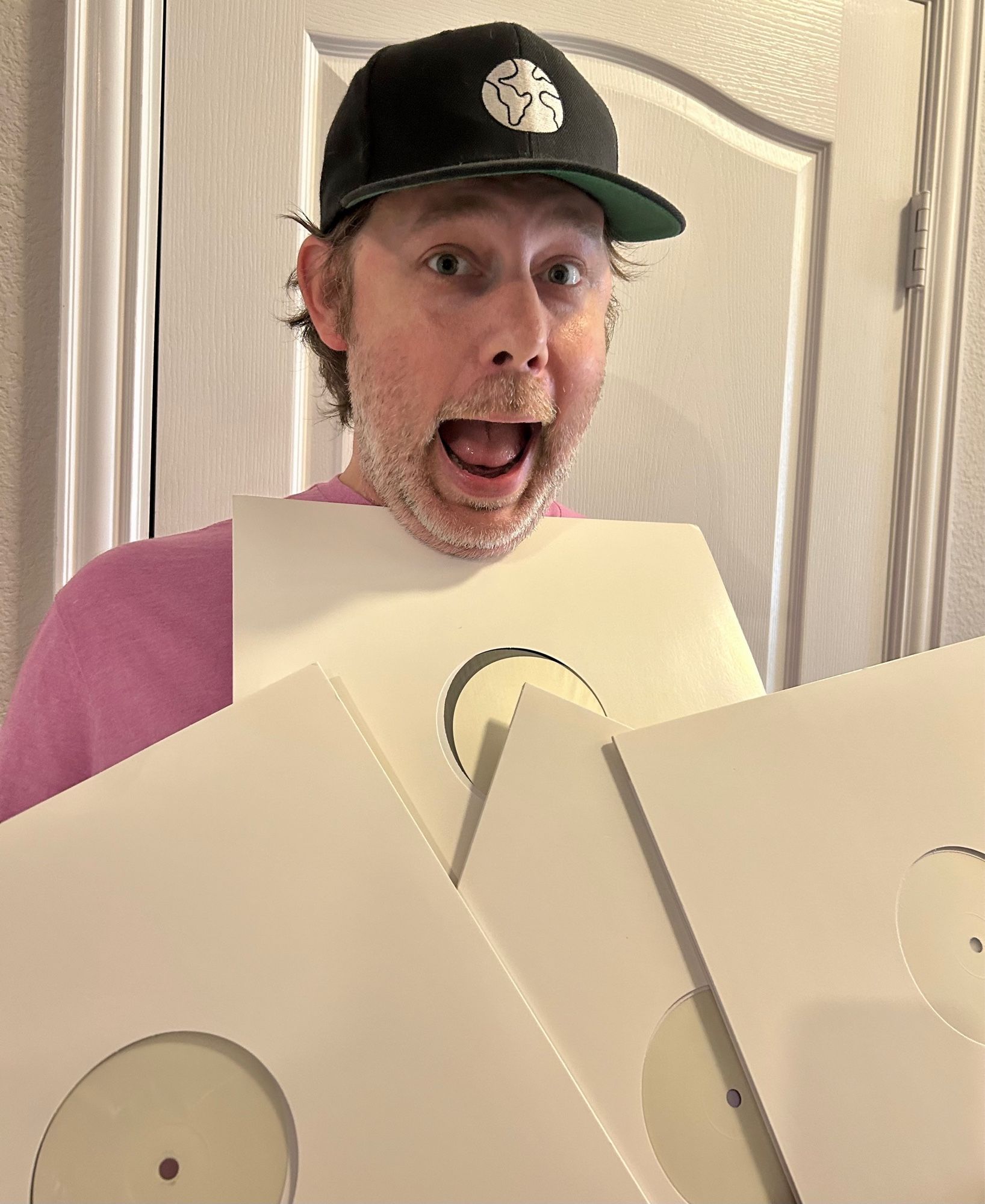 Cool Chris holding 4 unmarked LPs