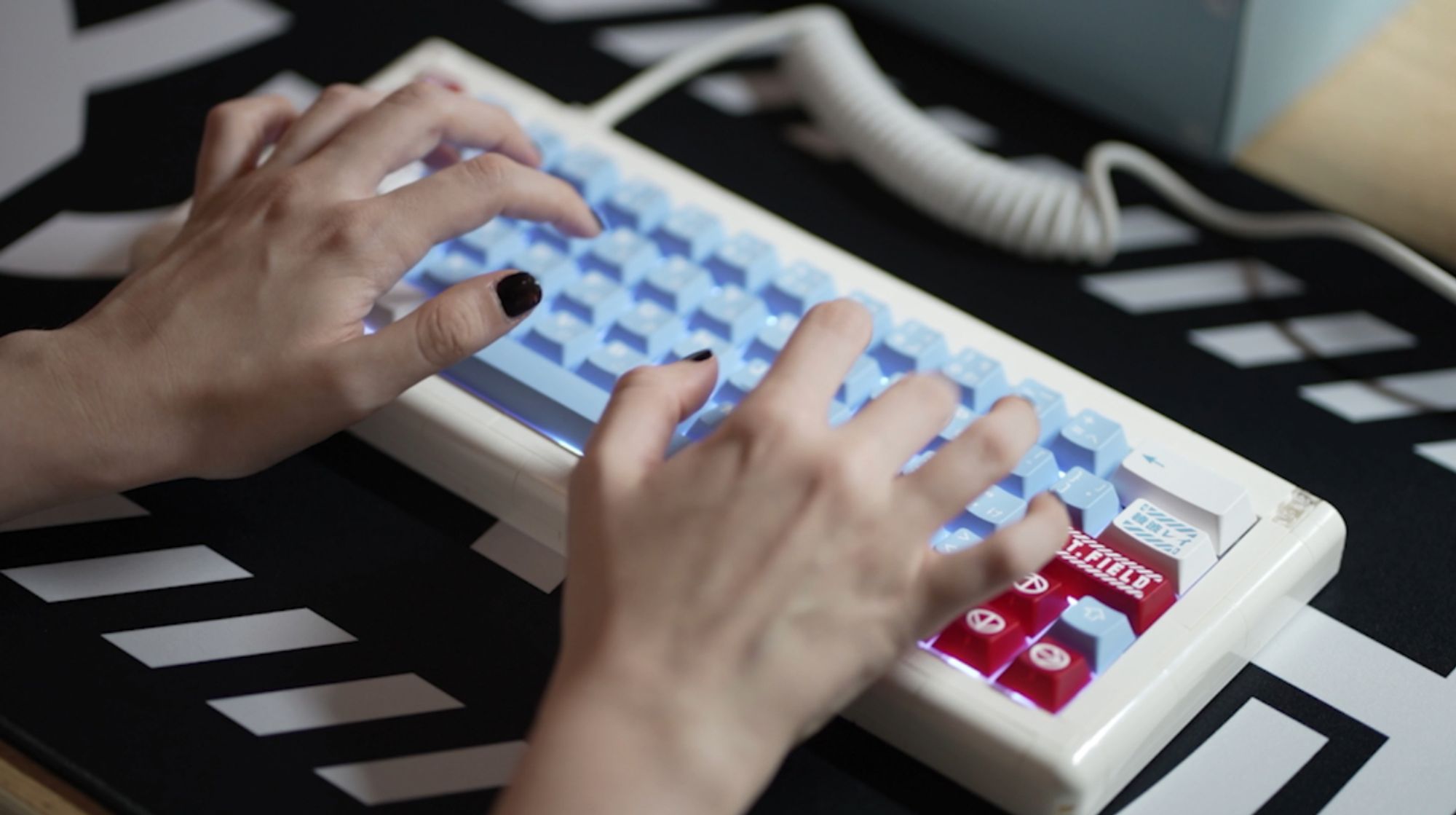 hands with black nail polish typing on an Adam keyboard (built from Lego pieces) with Evangelion-inspired Lilith keycaps on a black meka deskmat