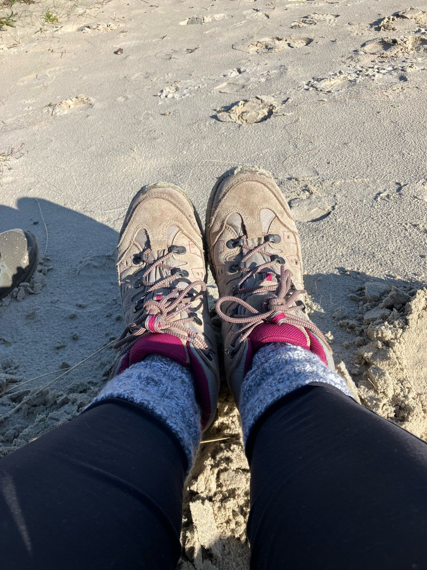 Wandelschoenen met grijze sokken in zand