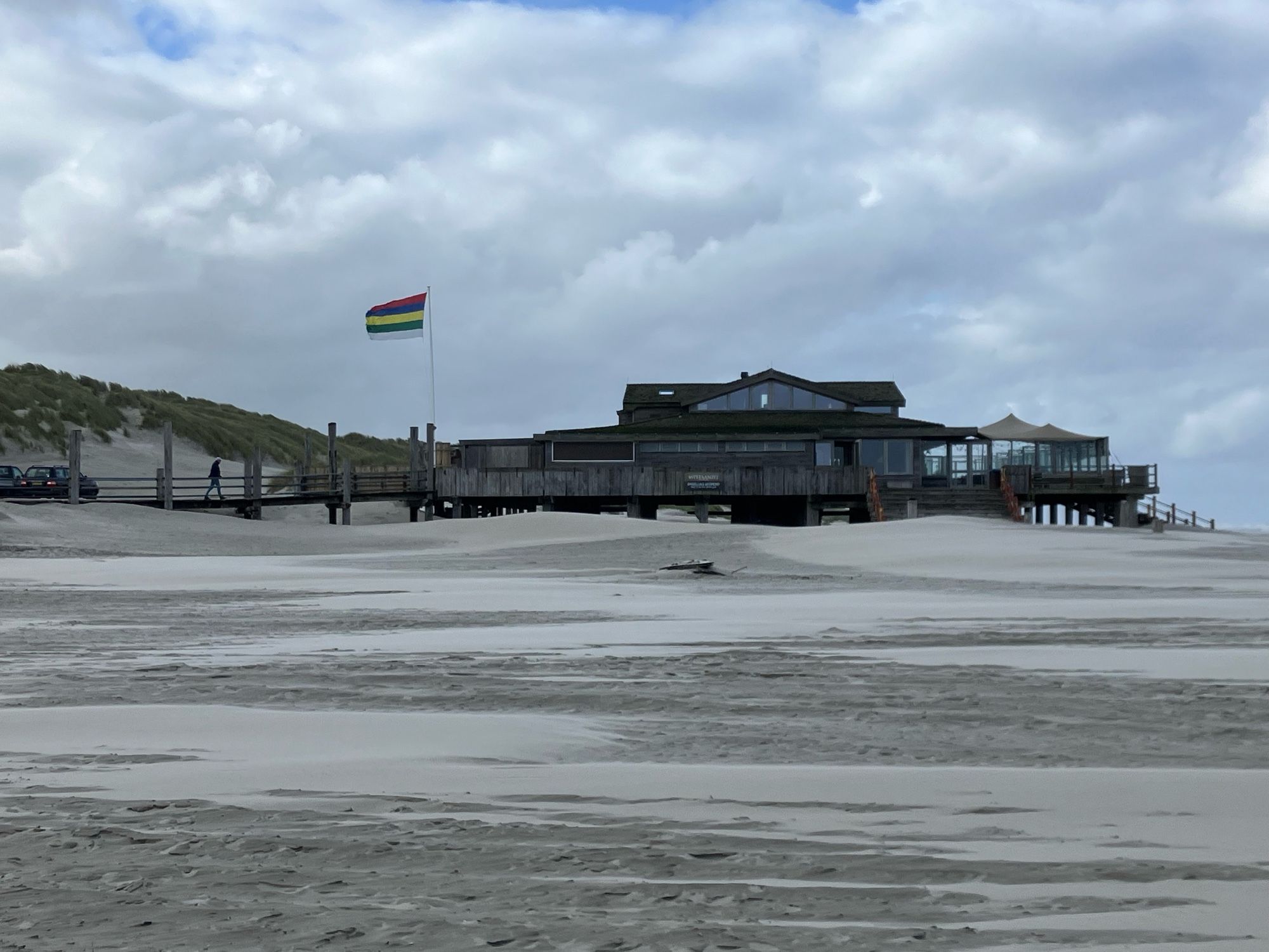 Strand, in de verte houten strandtent op palen