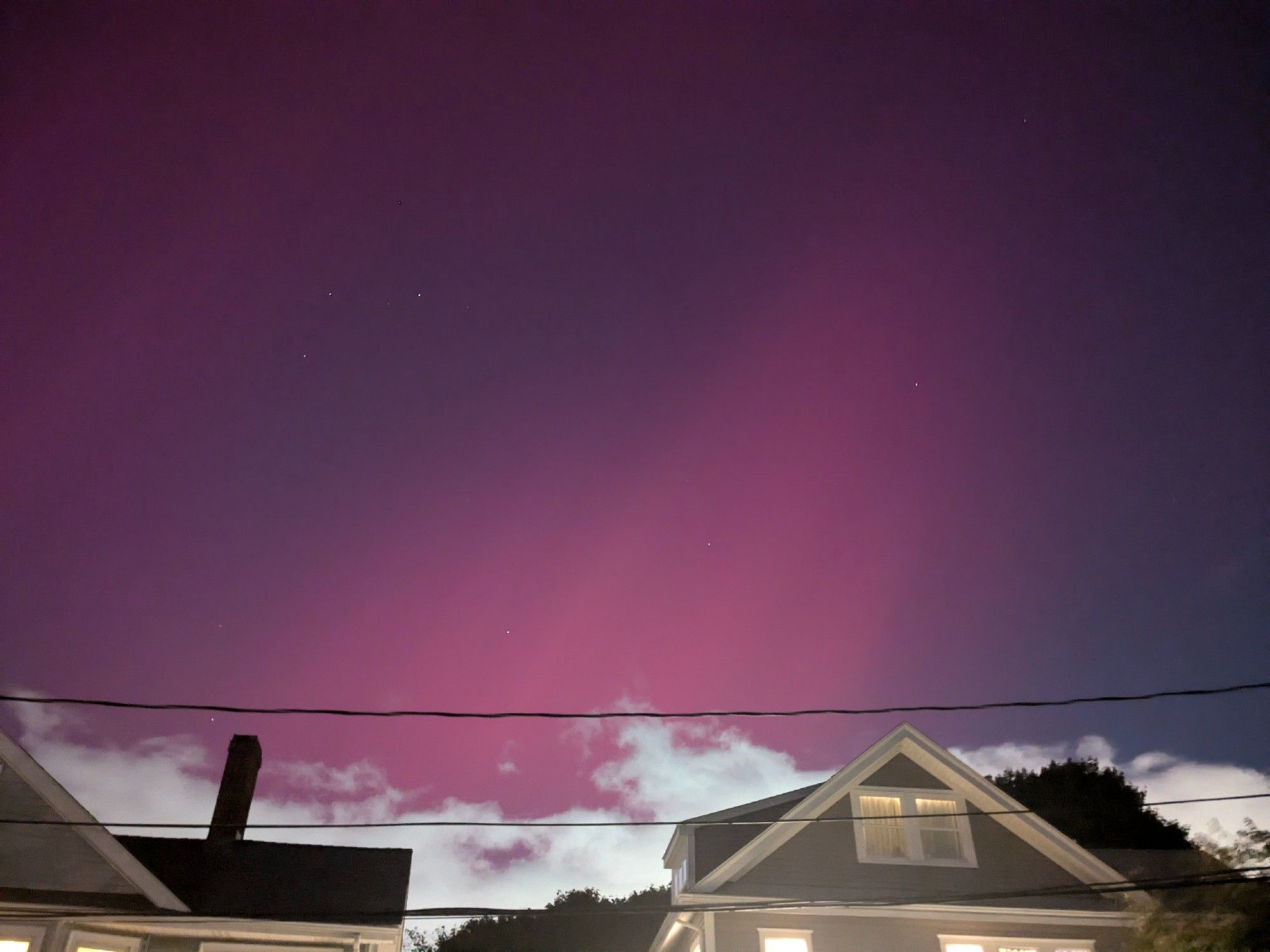 Northern lights showing deep magenta over some suburban houses