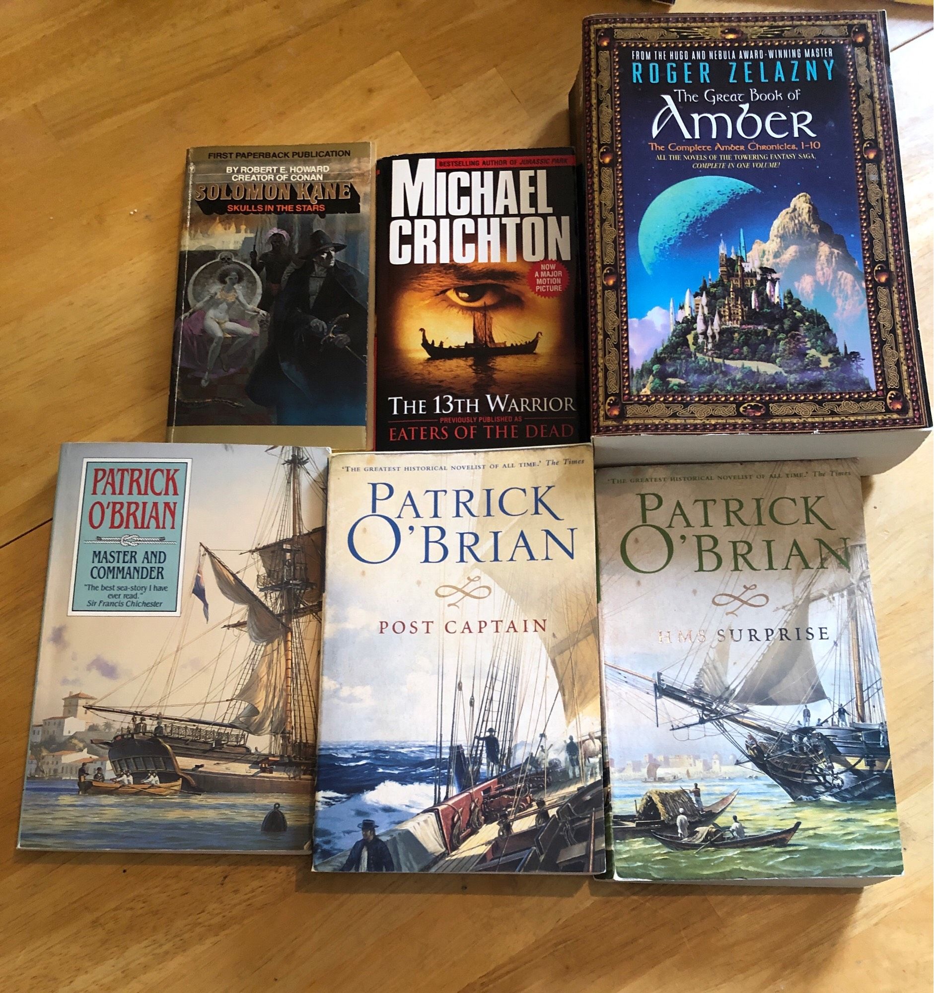 My impressive haul from the Calgary Reads Big Book Sale, including SKULLS IN THE STARS by Robert E. Howard, Michael Crichton’s THE THIRTEENTH WARRIOR (AKA EATERS OF THE DEAD, MASTER AND COMMANDER, POST CAPTAIN, and HMS SURPRISE by Patrick O’Brian, and THE GREAT BOOK OF AMBER by Roger Zelazny