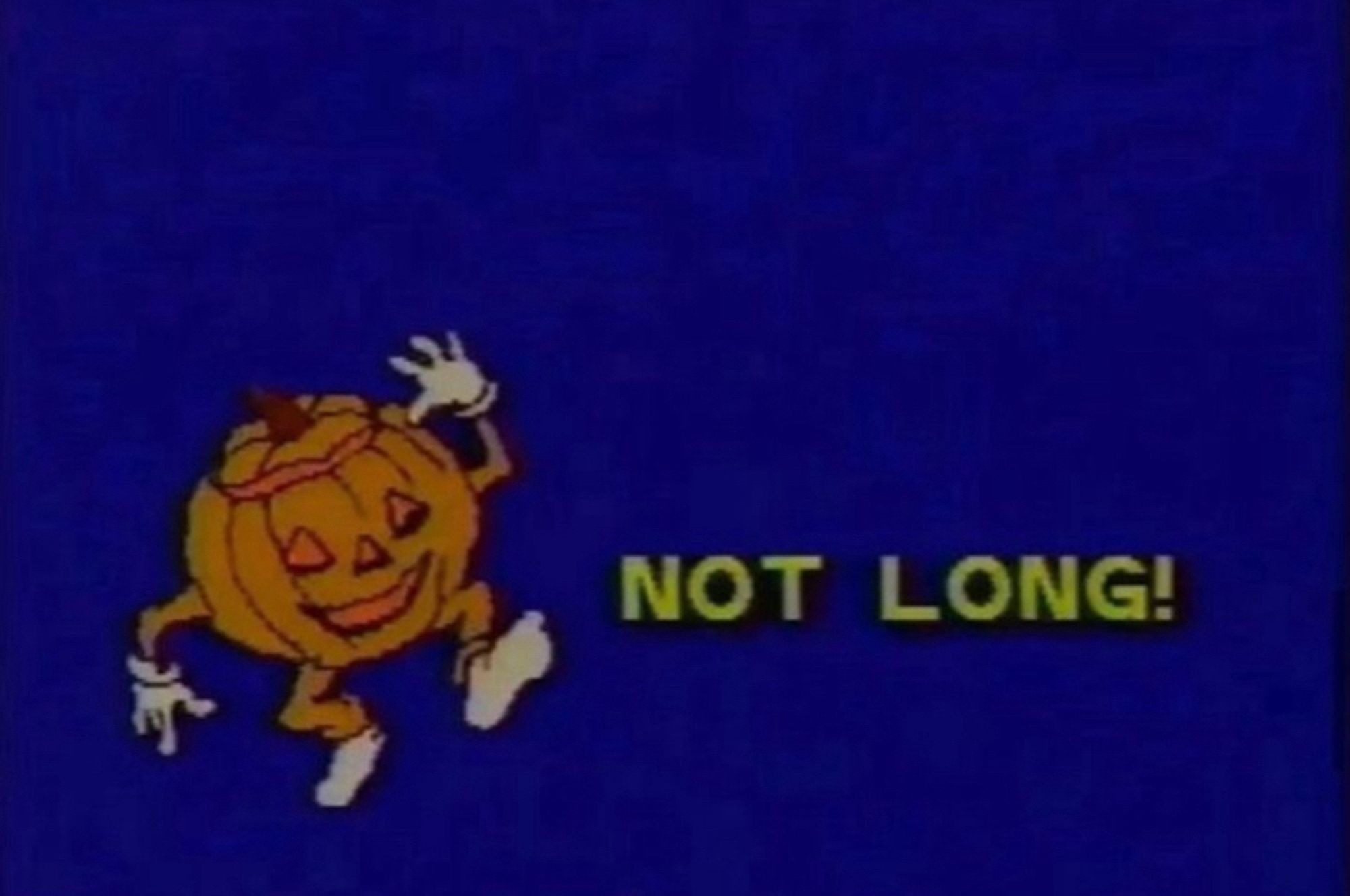 A screengrab from what looks like an 80s or 90s spooky tv special for kids, it's a plain blue blue background with a little illustrated dancing jack-o-lantern man and the words NOT LONG!