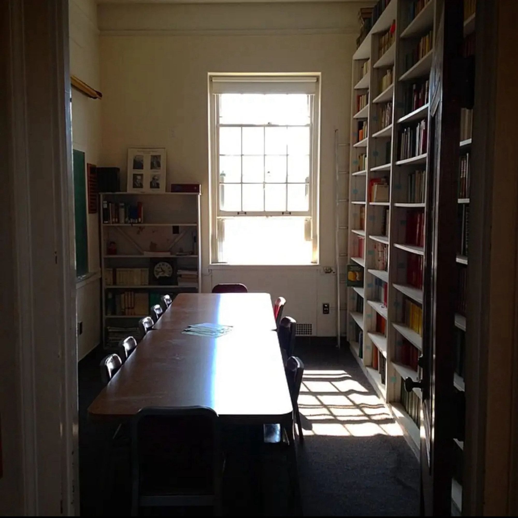 A very small room lined with bookshelves with a lovely window at one end that overlooked a little courtyard. There's a long seminar table in the middle of the room.