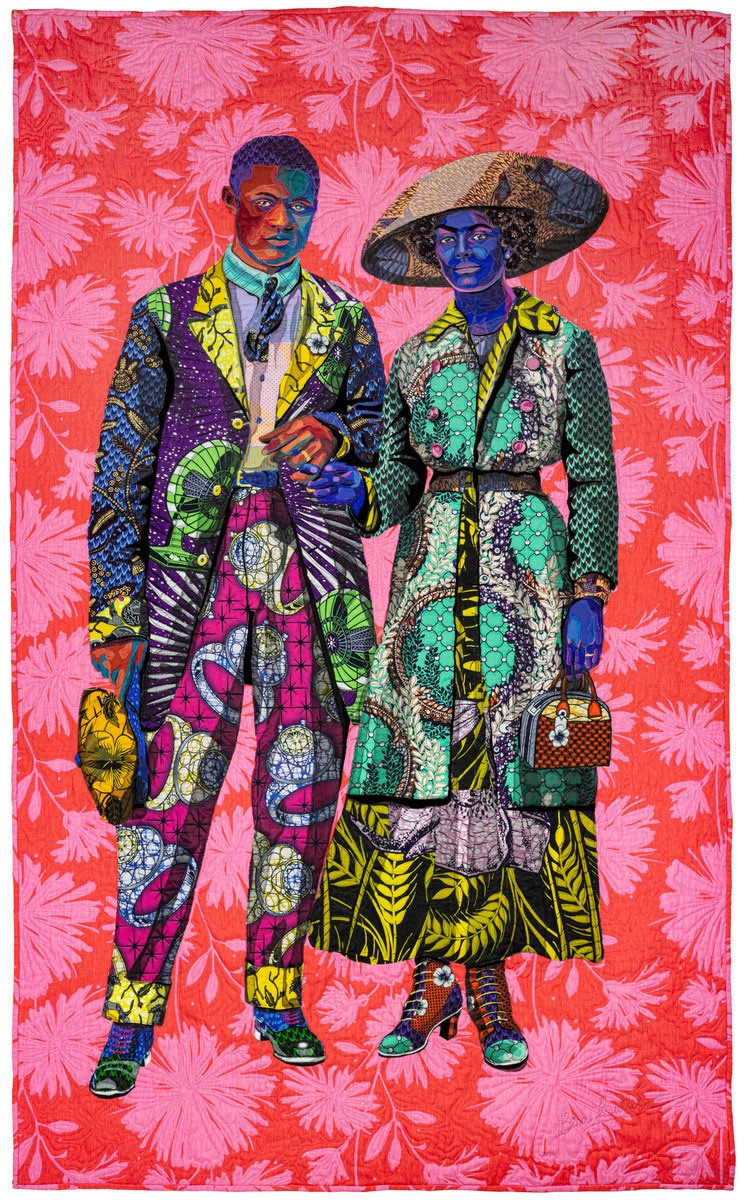 A quilt featuring a gorgeously outfitted Black couple wearing early 20th century fashions. They are created from colorful fabrics in pinks, yellows, blues, purples, aquas. They’re set against a vibrant red and pink floral backdrop fabric