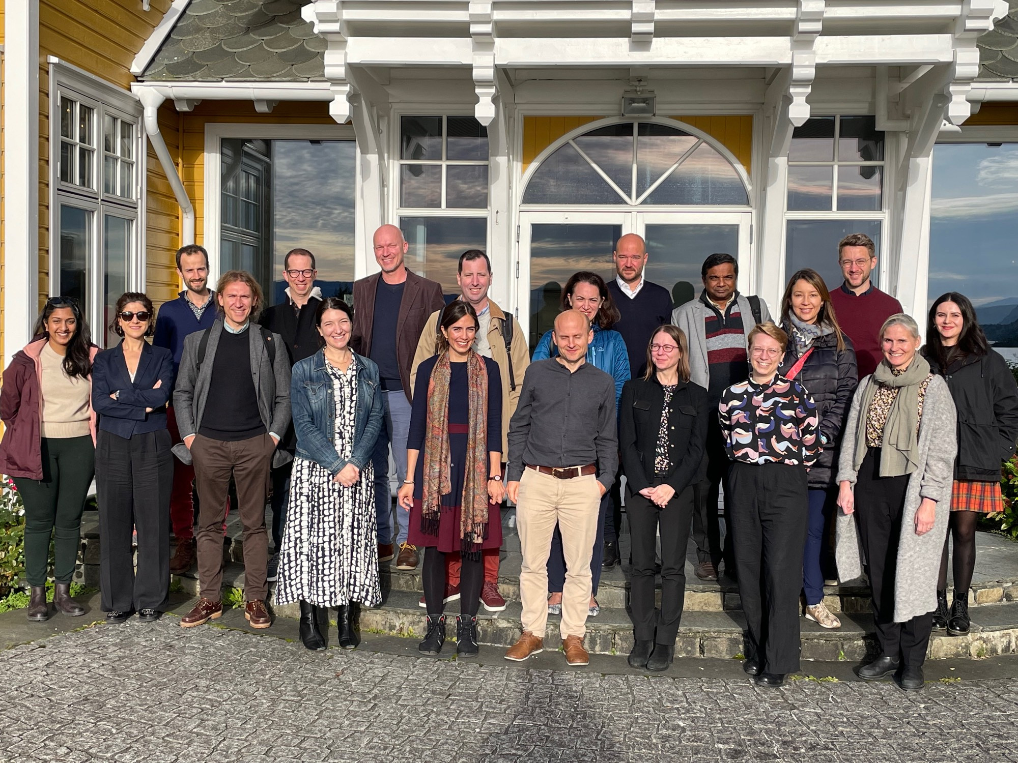 Twenty adults standing together outside for a group photo.