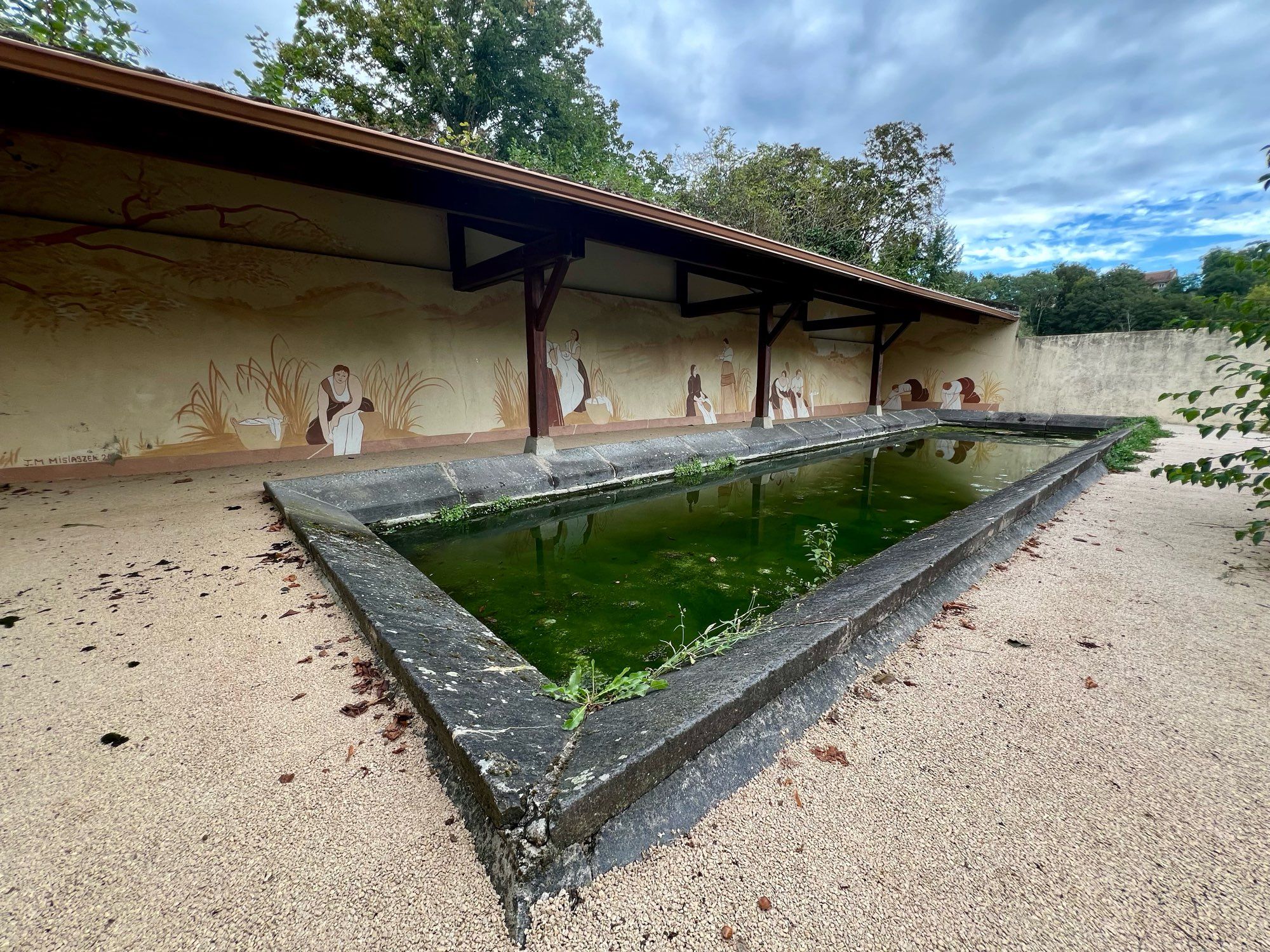 Un lavoir, autrefois utilisé dans le village. Si le préau et le tour sont bien entretenus, le bassin en lui-même est rempli d’une eau certes propre mais emplie d’une végétation verdâtre peu inspirante pour faire trempette, notamment à cause de tous ses insectes aquatiques.