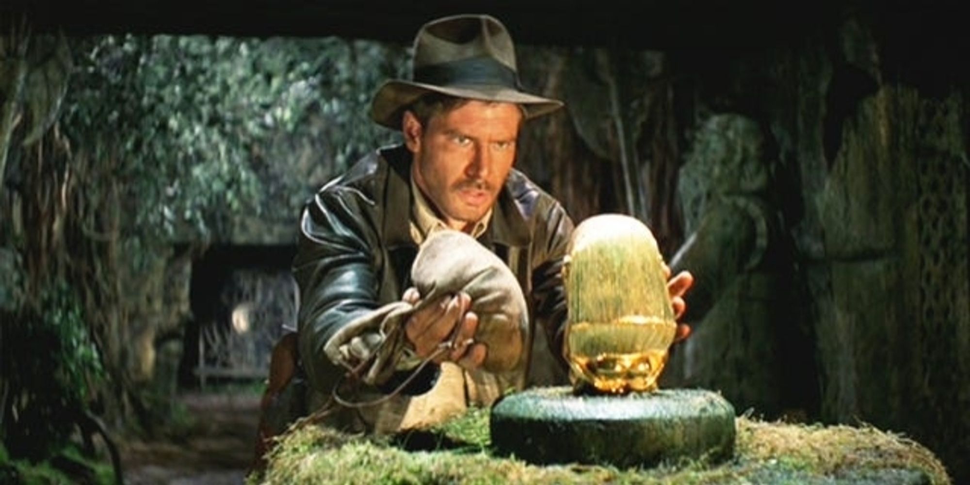 Indiana Jones tauscht hochkonzentriert eine goldene Statue gegen einen Sandsack aus.