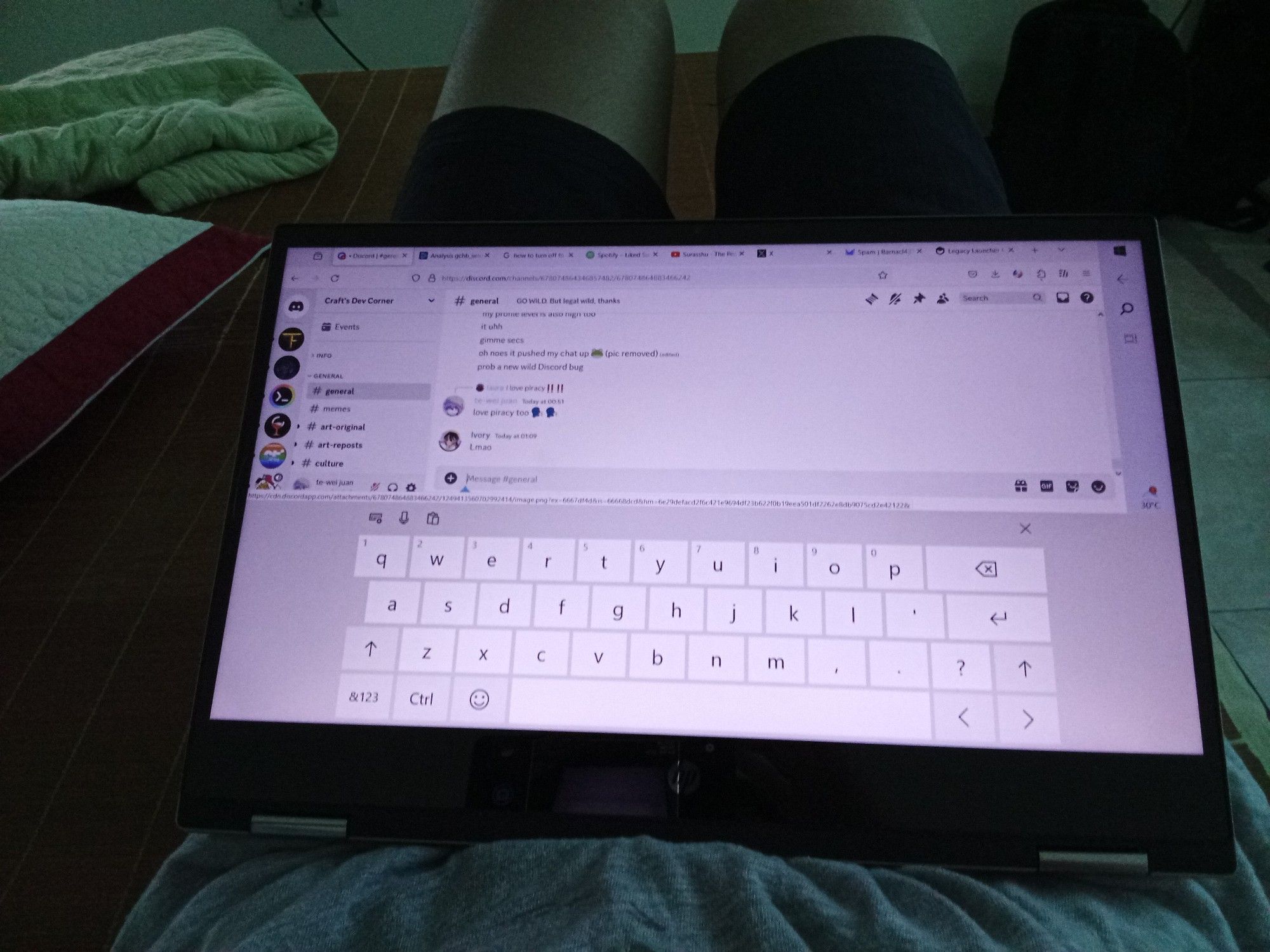 An HP Pavilion x360 being folded back the keyboard showing virtual on-screen keyboard and Discord opening.