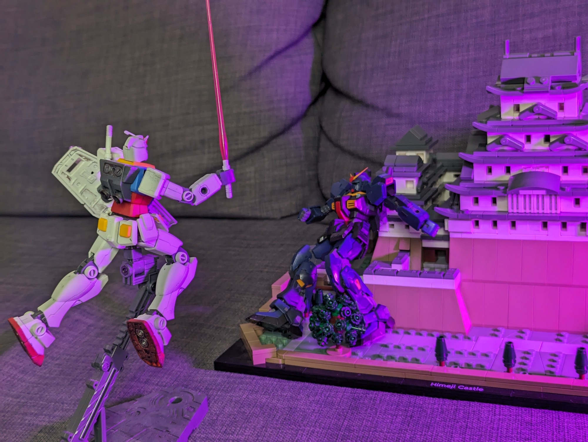 2 gunpla, crashing into a Lego Himeji castle, as if in combat