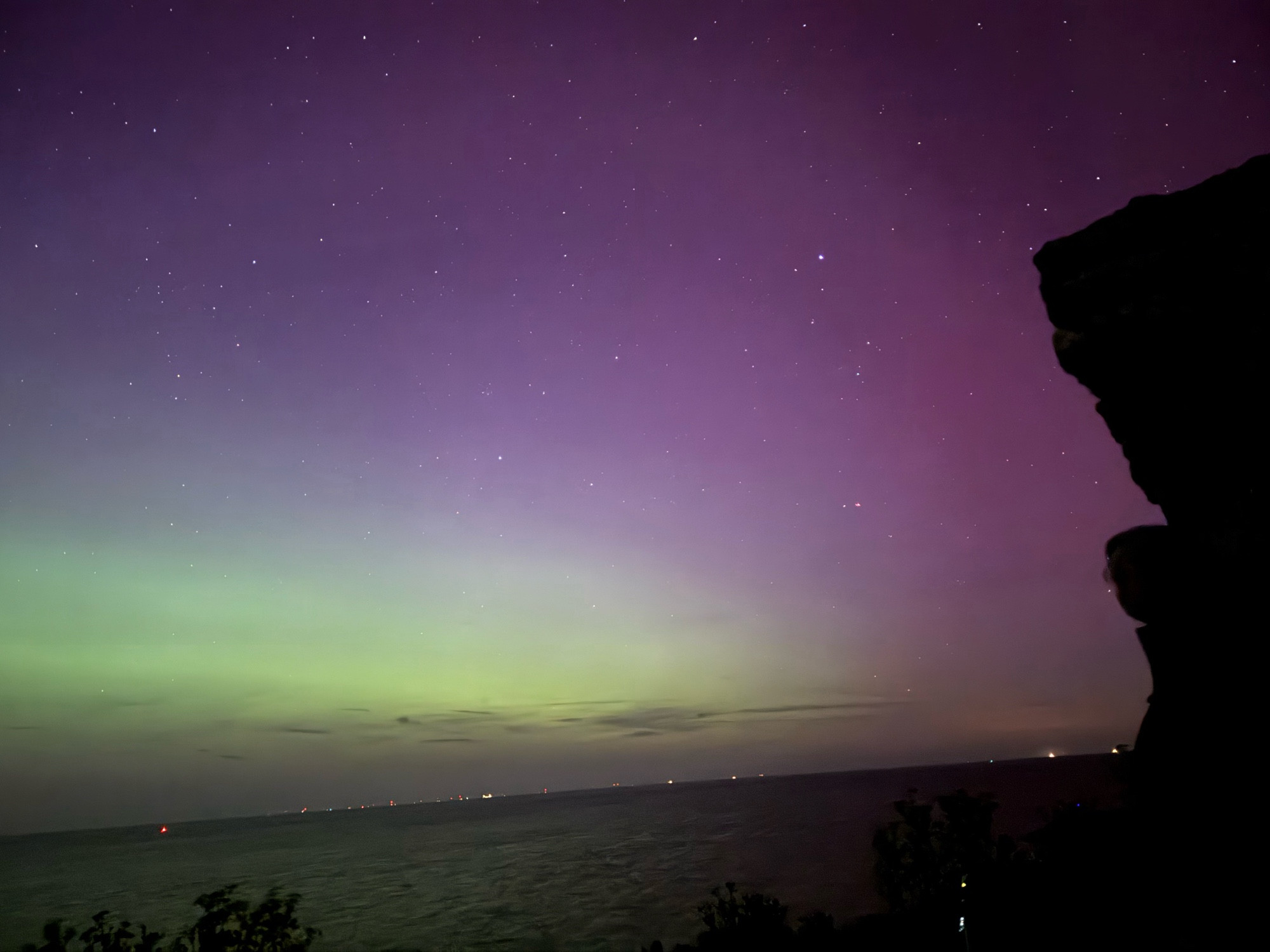 Reculver towers facing slightly north east. The aurora is making the sky fade from green to the left through purple and finally pink at the right hand side.