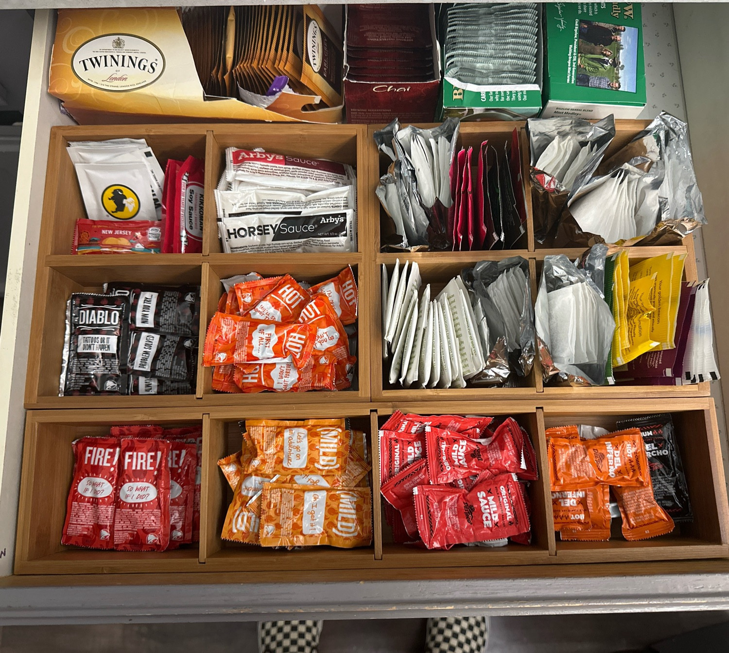 Kitchen drawer organized with fast food sauces and tea