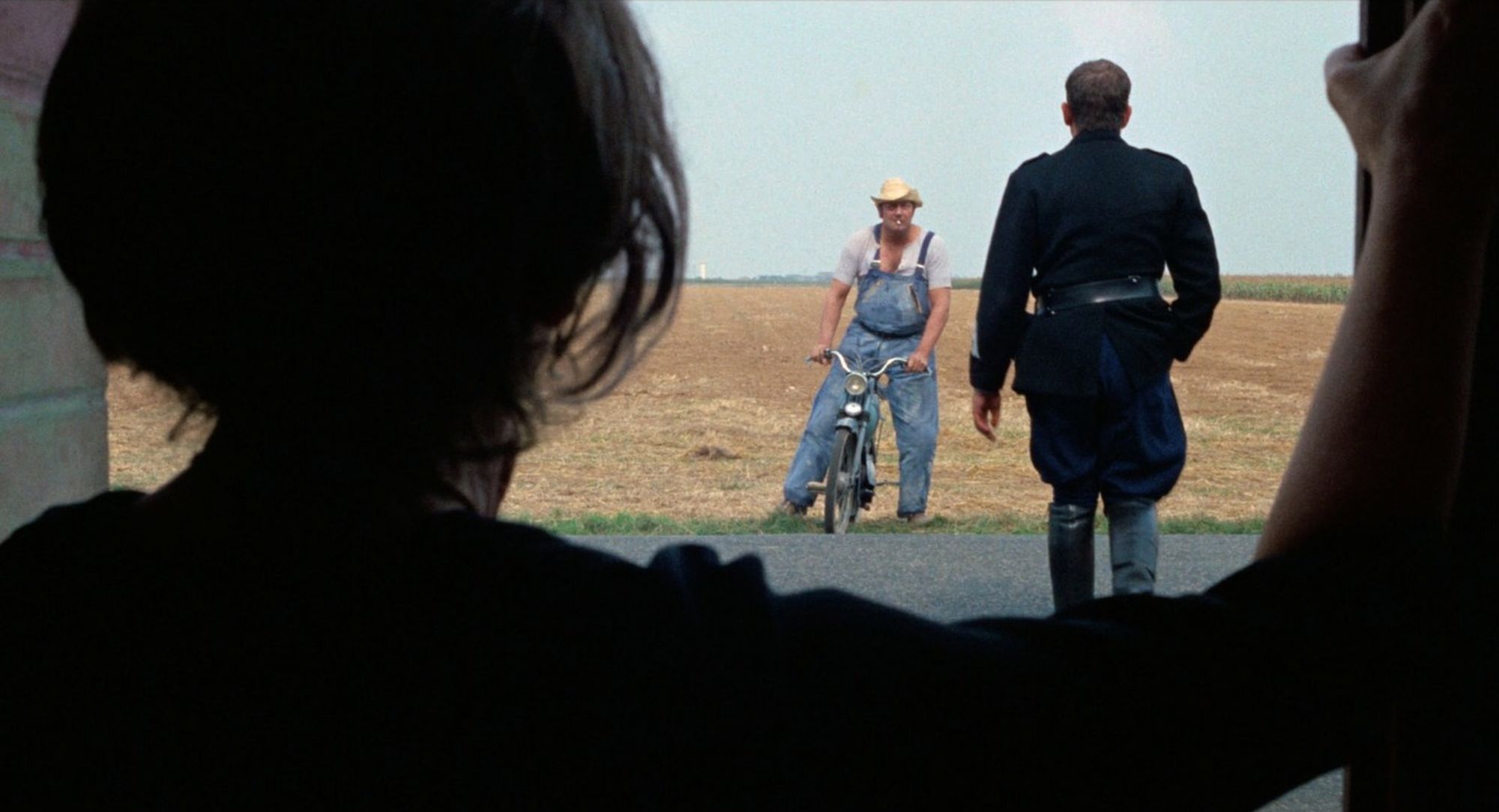 John Ford eat your heart out. Looking out a door over a shoulder at some French hillbilly on a bike and a French cop.