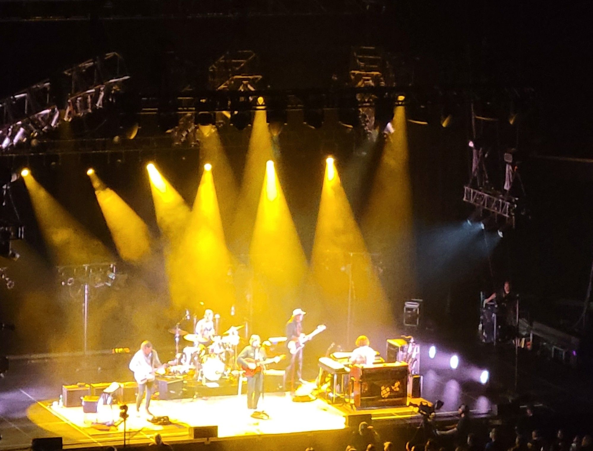 Sturgill Simpson and his band play on stage at Rupp Arena, under the golden glow of several spotlights. You can't tell from this photo, but drummer Miles Miller is wearing a UK jersey.