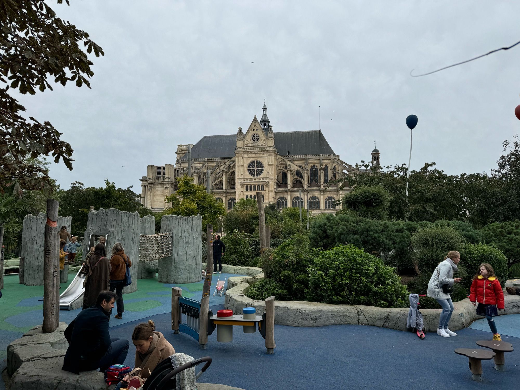 Saint Eustache church in its large gothicness with a playground in the foreground