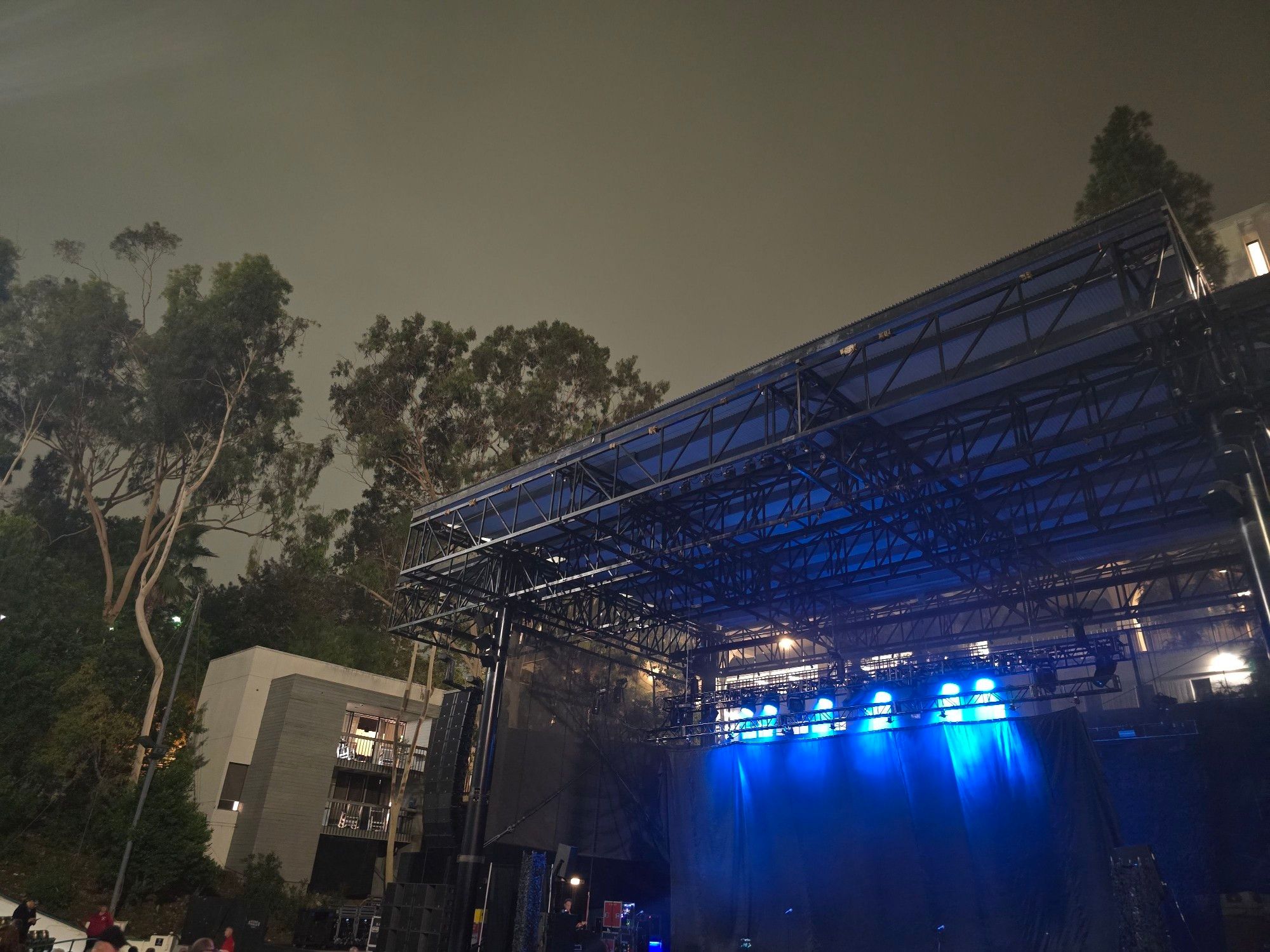 An amphitheater stage with blue lights shining down waiting for the next band to come on