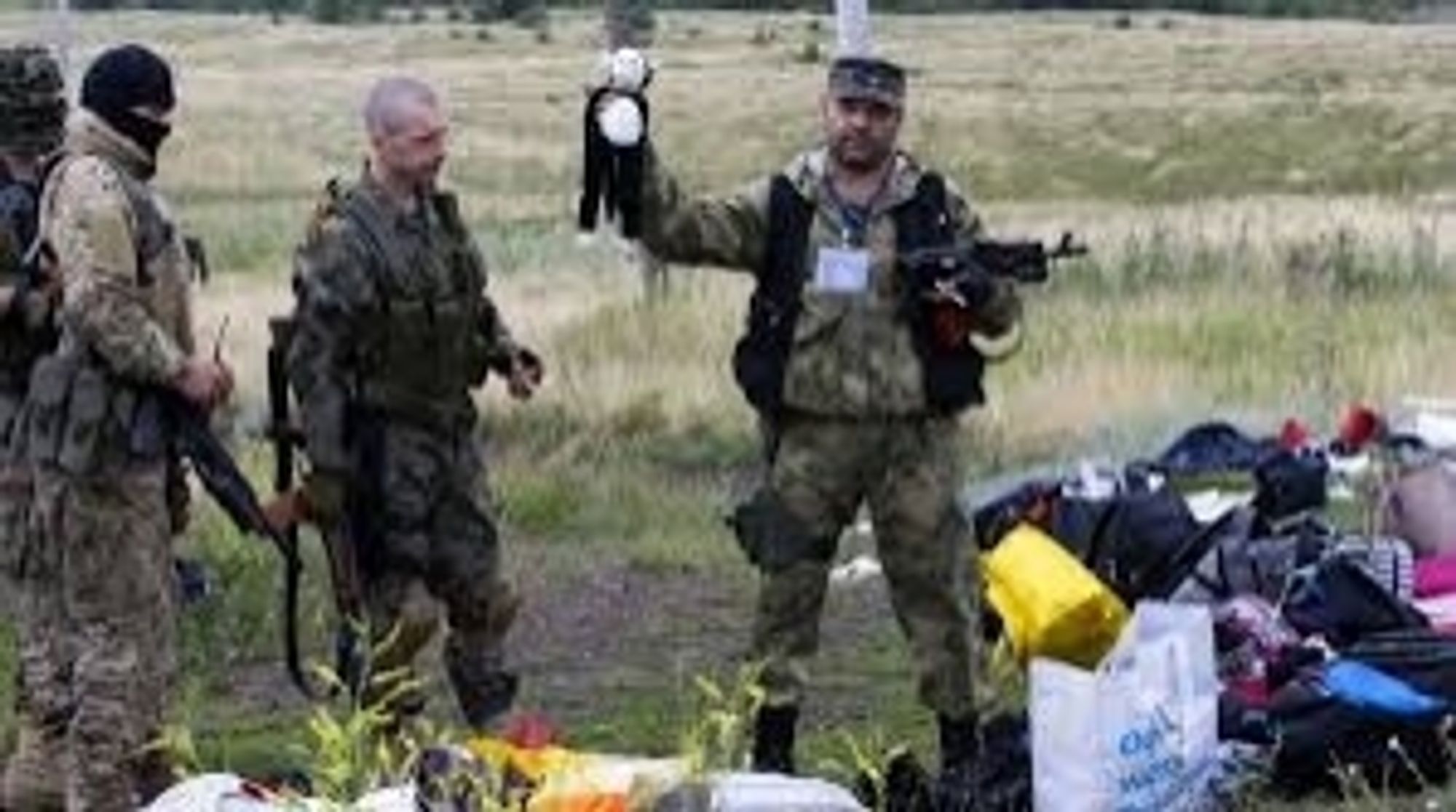 ruSSian soldiers posing with looted MH17 baggage