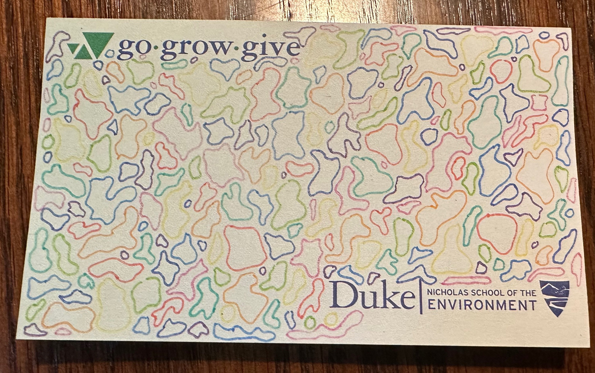 A pad of paper with a label on the bottom from Duke University’s Nicholas School of the Environment. The tagline on the top says Go, Grow, Give. The paper itself is filled with wiggly outlined shapes all drawn to interlock and fill in all of the space on the paper.