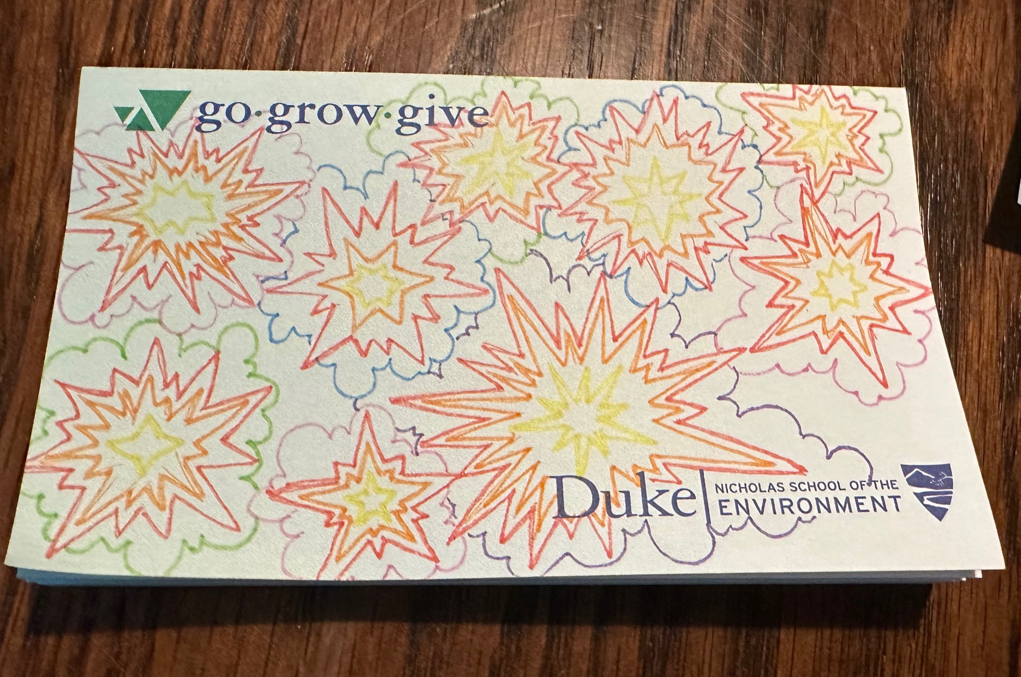 A pad of paper with a label on the bottom from Duke University’s Nicholas School of the Environment. The tagline on the top says Go, Grow, Give. The paper itself is full of colorful explosions drawn in colored pens, with the smoke cloud behind each one being a different color.