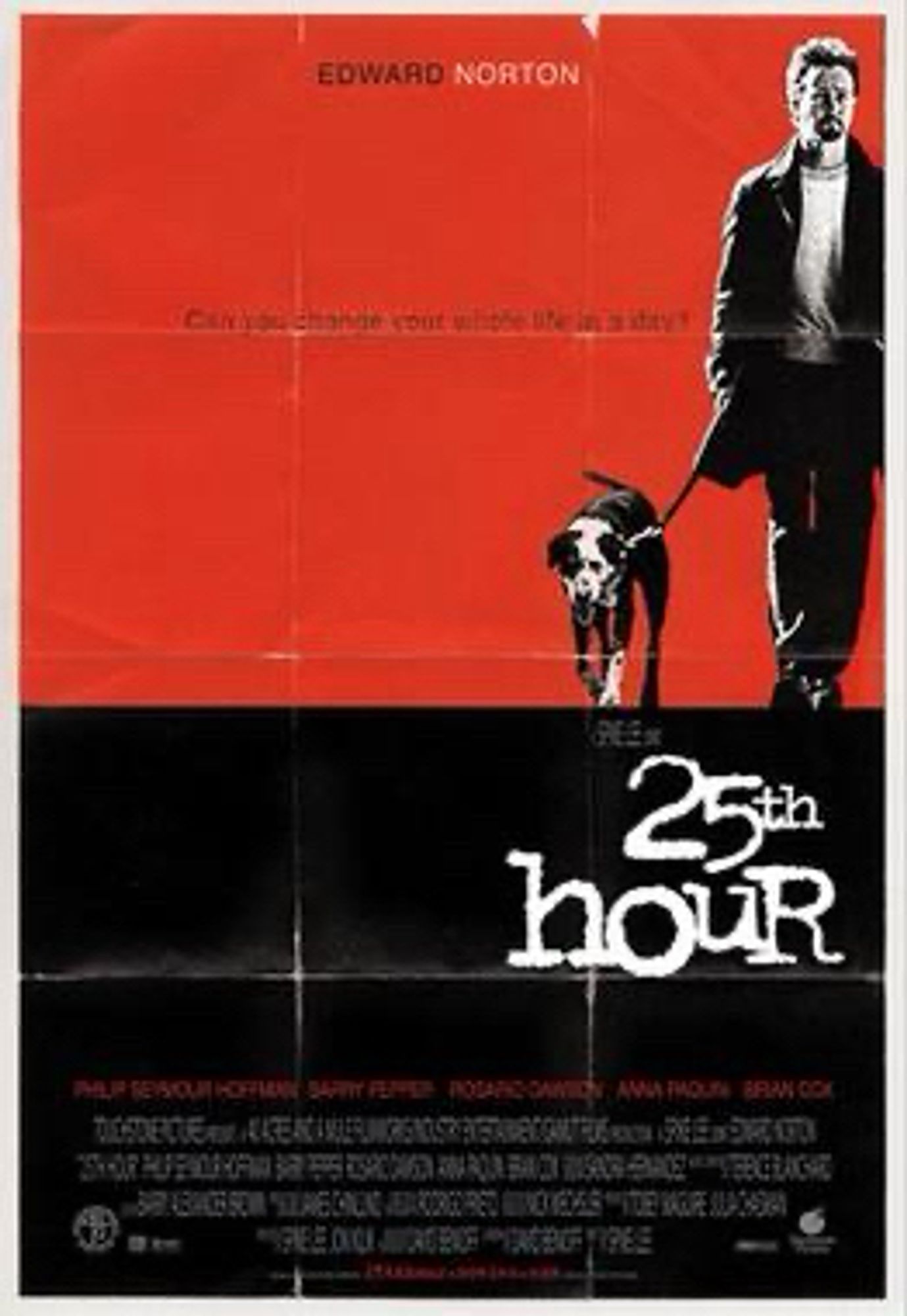 The original movie poster for Spike Lee’s 25th Hour. The bottom half is black, with the title of the movie in a typewriter-style typeface. The top half is a red field of color with Edward Norton walking a dog shoved all the way over to the right. There’s a line of text near the top: “Can you change your entire life in a day?”