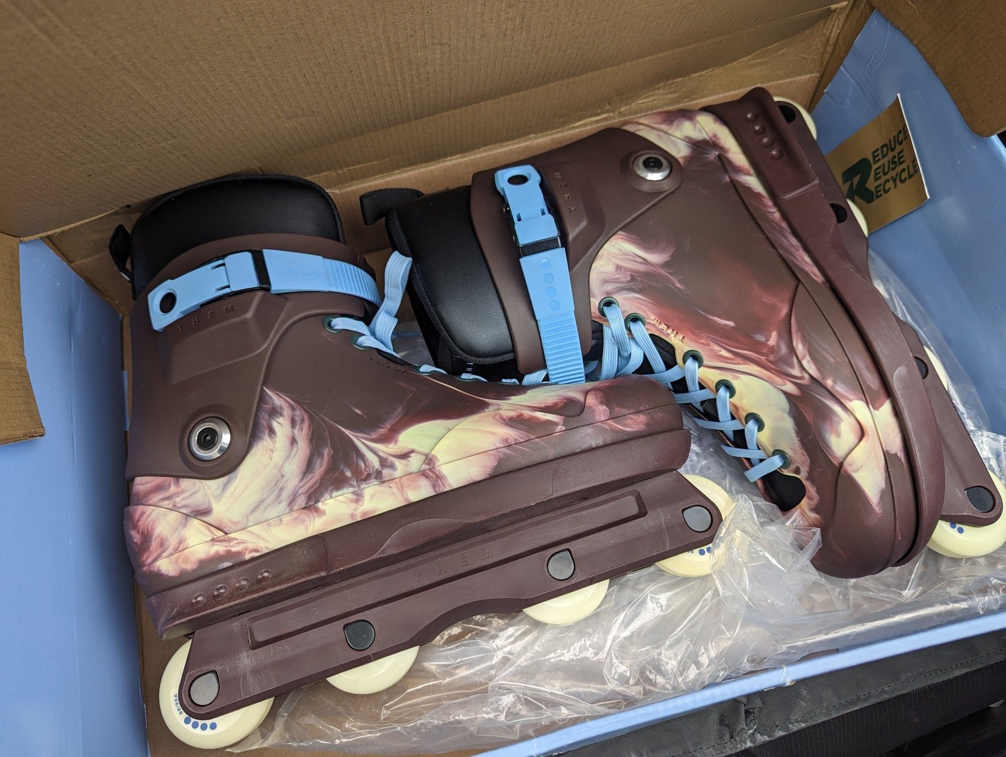 brand new rollerblades still in the box. they are a deep brown-ish purple with white swirls and blue laces. they are pretty.