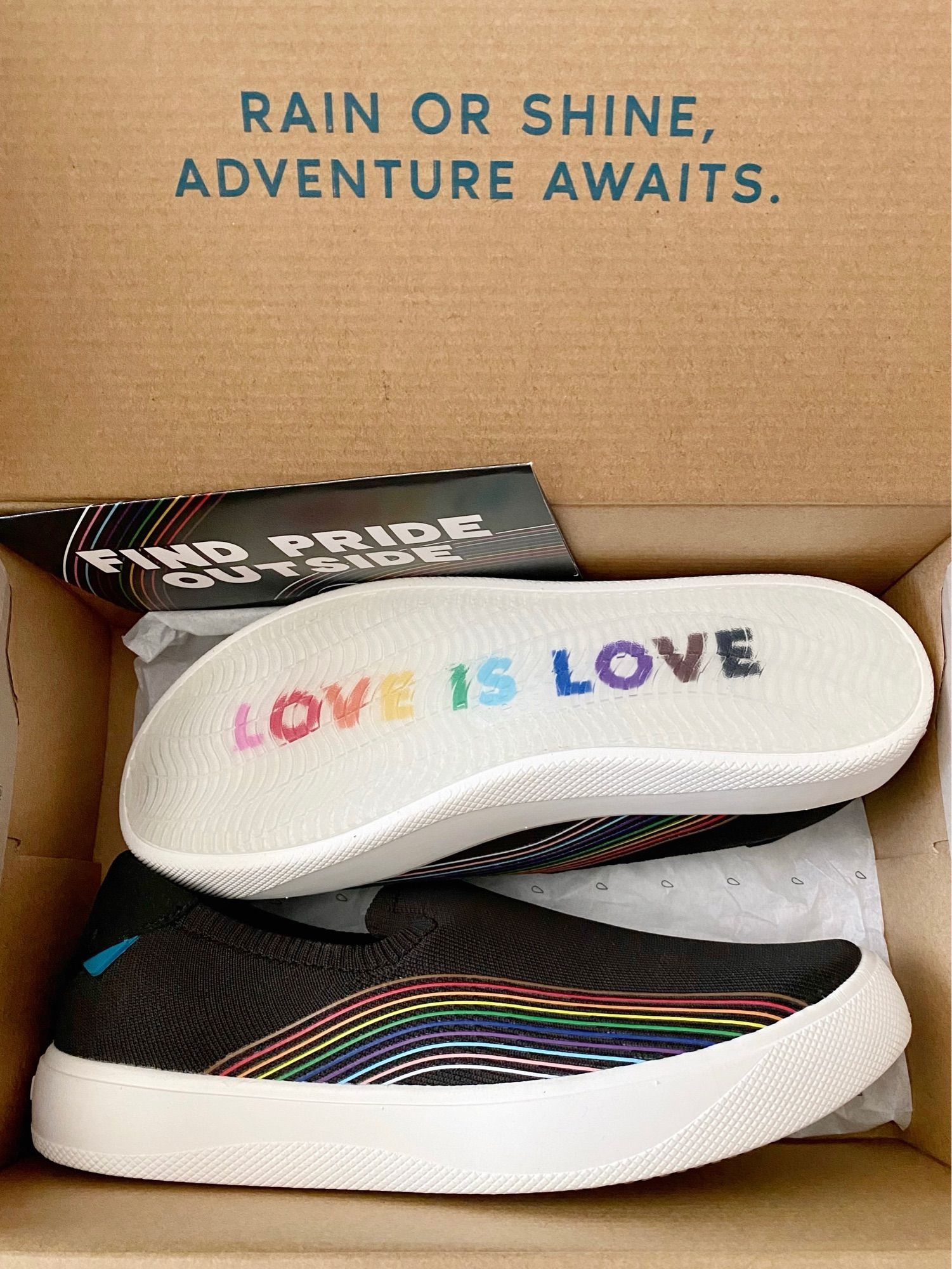 Vessi pride 2023 boardwalk shoes. Black slip-on shoes with rainbow coloured lines and “love is love” on the bottom of white soles