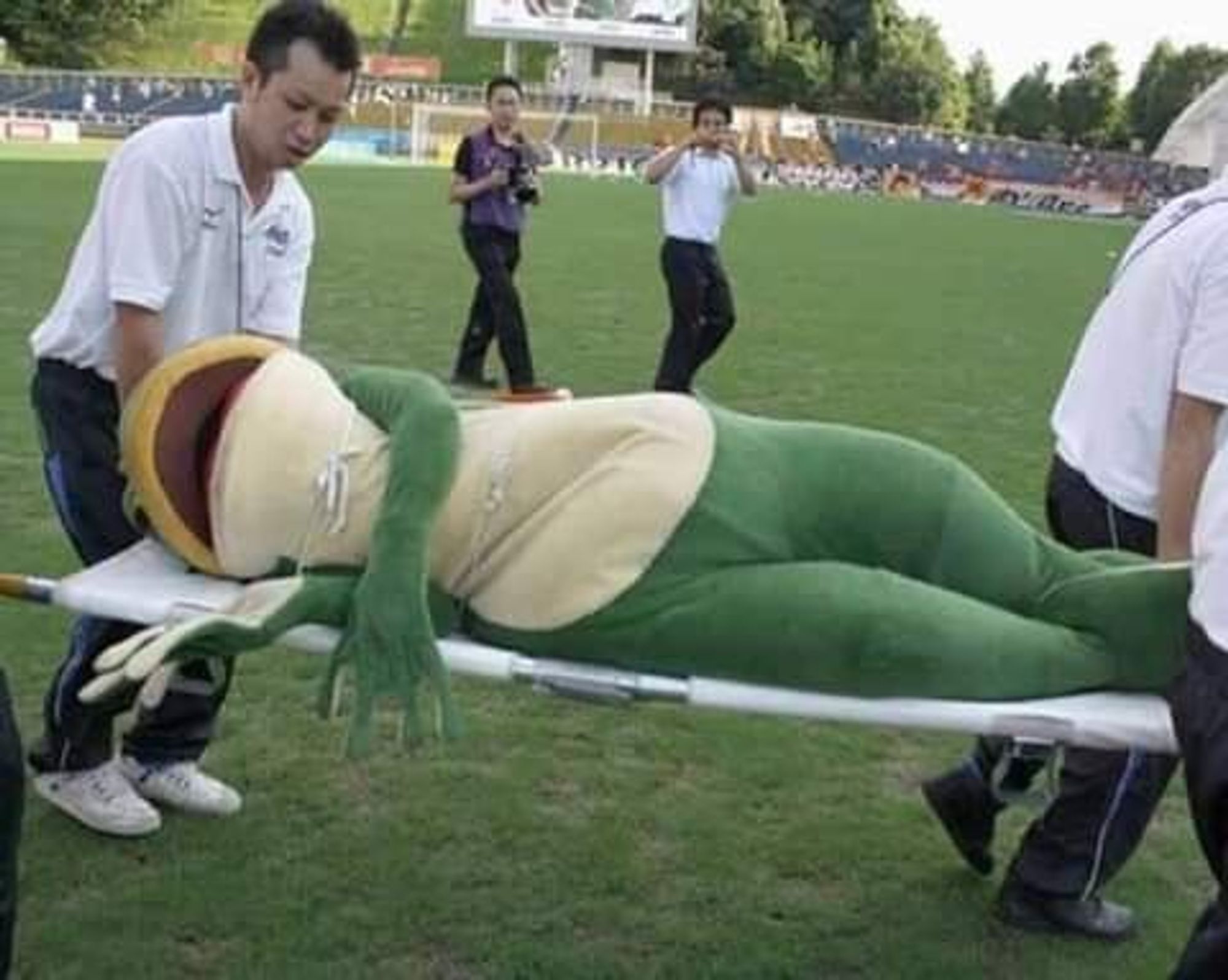 Frog mascot being carried on a stretcher.