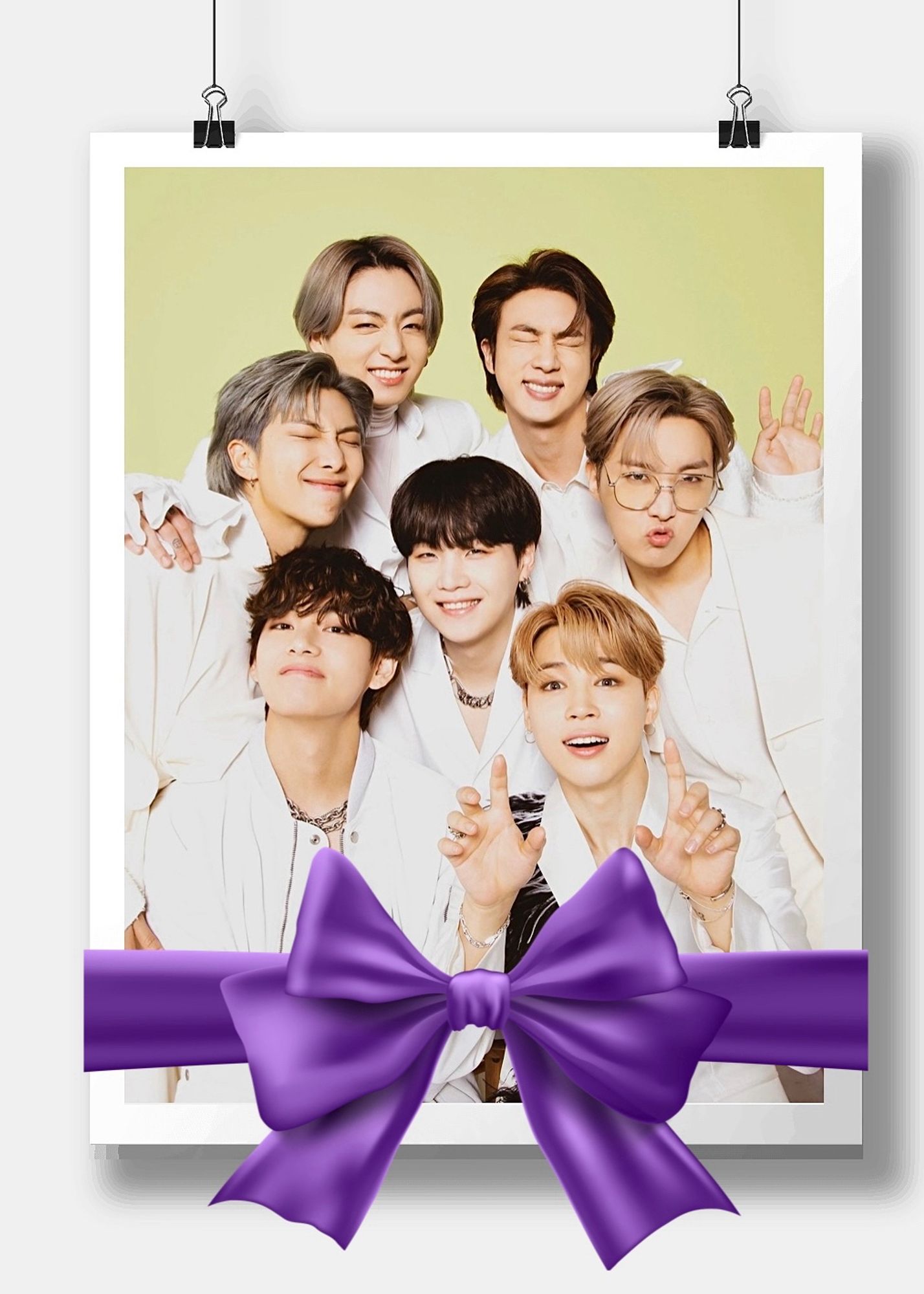 All 7 members of BTS are wearing white suits with SUGA (Min Yoongi) in the center and with a yellow background.

Photo Edit: original photo is placed within a white border with clips at the top to appear like it’s hanging with a white background behind it. A purple ribbon/bow is on top of the lower part of the “hanging” photo.