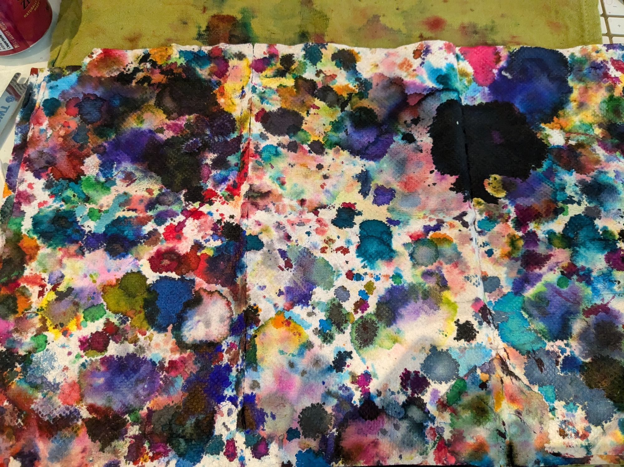 A paper towel spread out to show a kaleidoscope of ink stains from wiping the nibs of hundreds of fountain pens after filling.